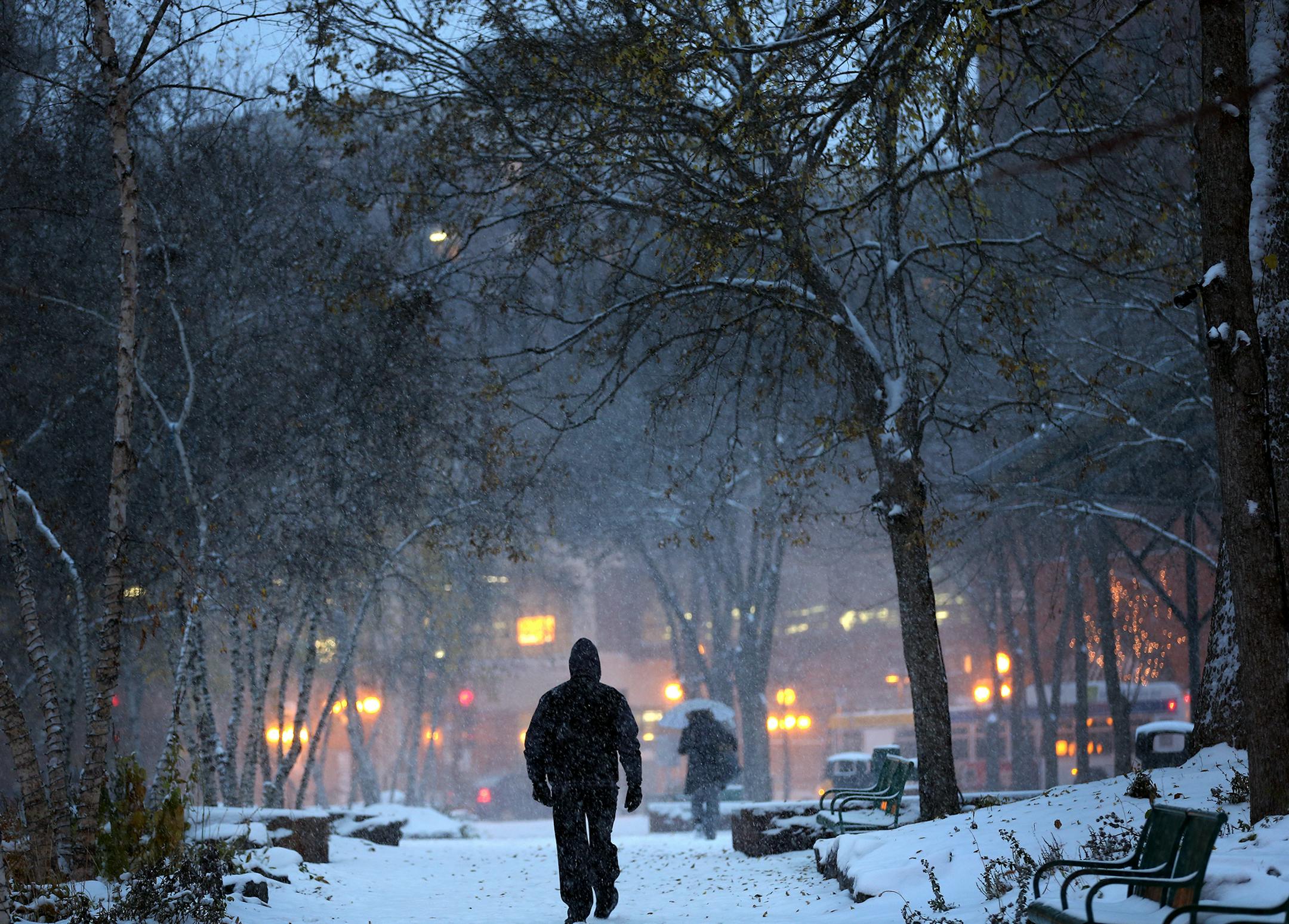 A man walks through Mears Park in downtown St. Paul during the first snowstorm of the season on Monday, November 10, 2014. ] LEILA NAVIDI leila.navidi@startribune.com /