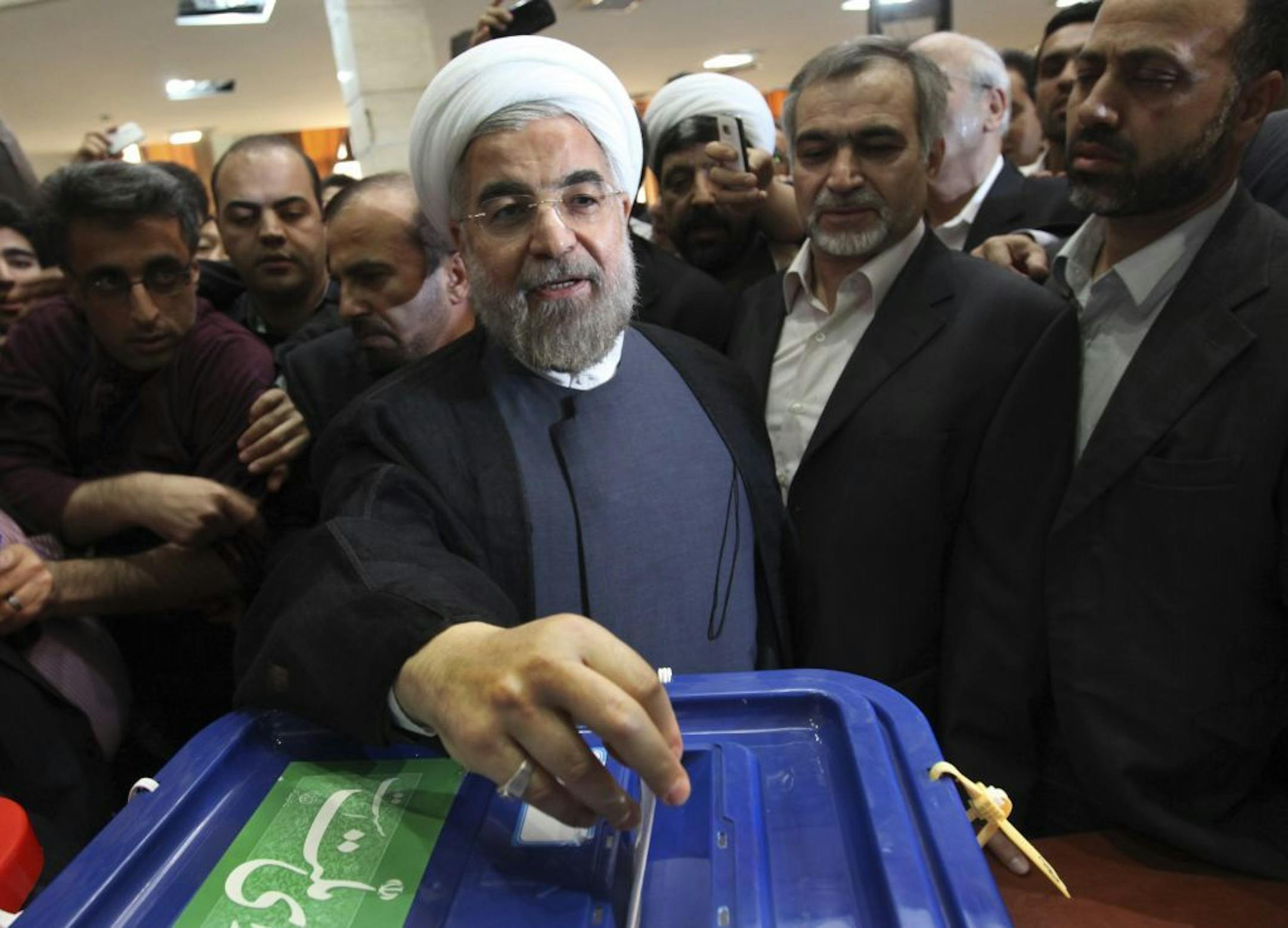 Iranian presidential candidate Hasan Rowhani, a former Iran's top nuclear negotiator, casts his ballot during presidential elections at a polling station in downtown Tehran, Iran, Friday, June 14, 2013.