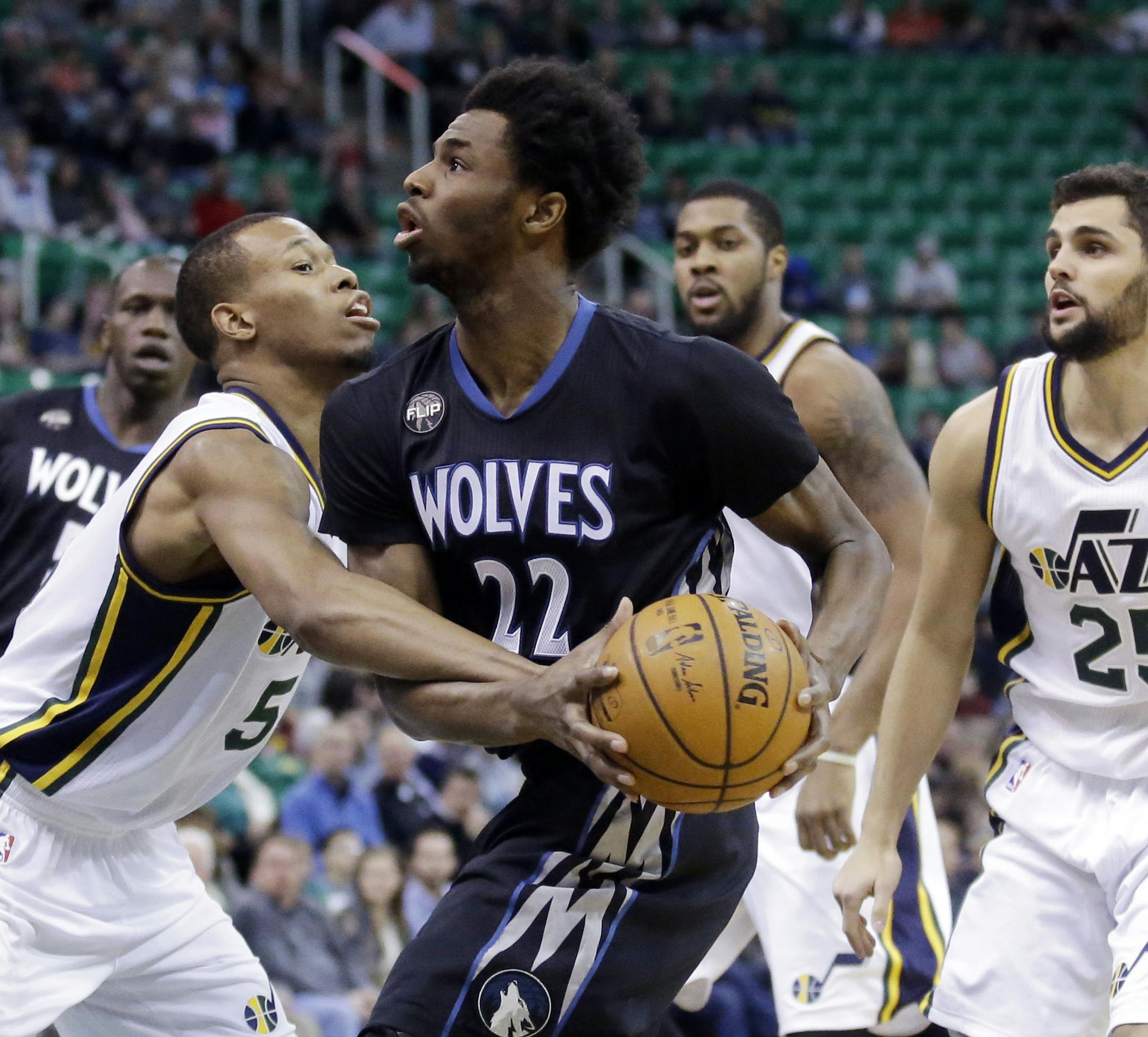 Minnesota Timberwolves guard Andrew Wiggins (22) goes to the basket as Utah Jazz's Rodney Hood (5) defends as Raul Neto (25) watches during the first quarter of an NBA basketball game Friday, Jan. 29, 2016, in Salt Lake City. (AP Photo/Rick Bowmer)