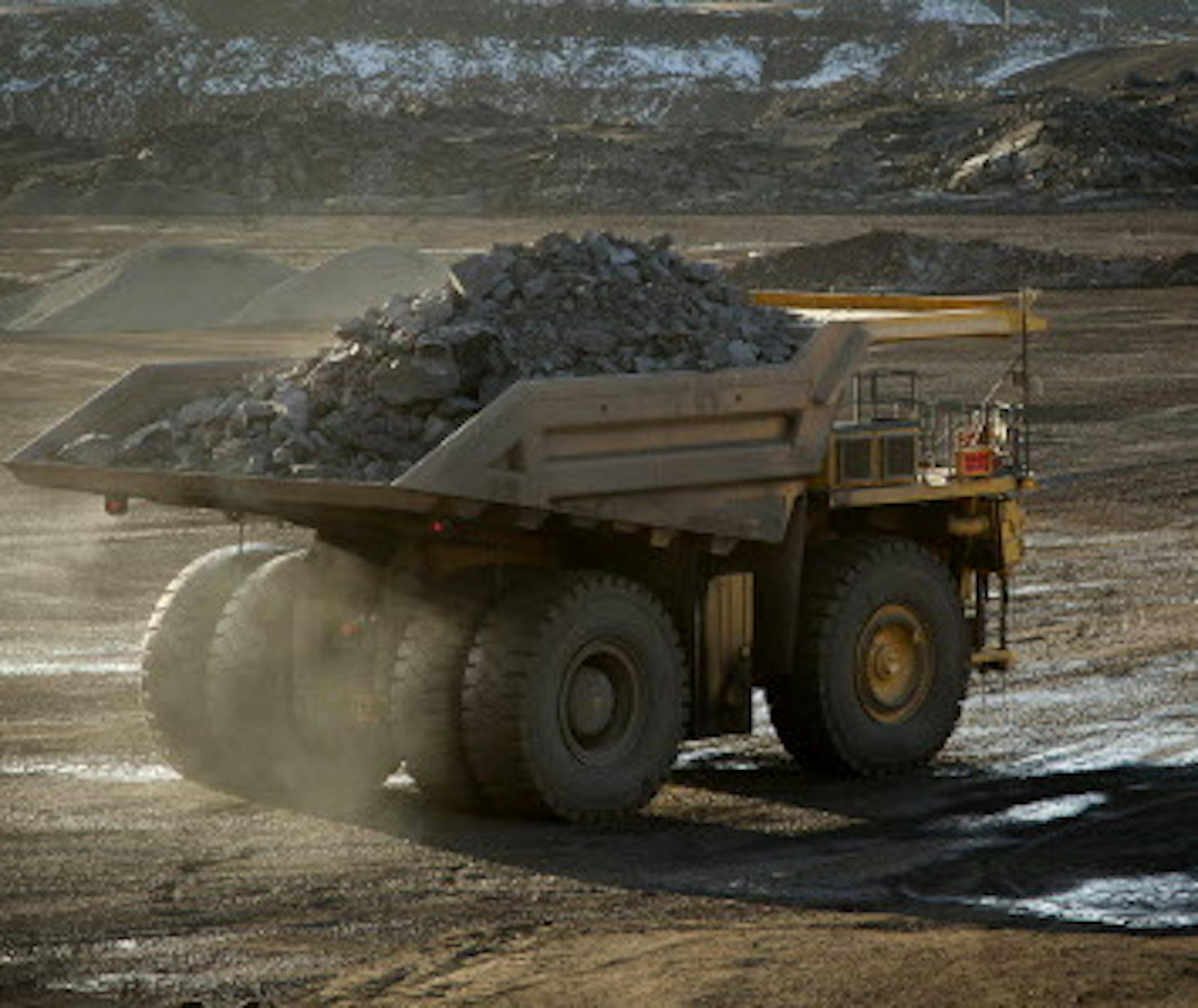 A 240-ton capacity production truck drives out of an open pit mine with a load of taconite heading to the Hibbing Taconite Co. pellet manufacturing plant, operated by Cliff's Natural Resources Inc., in Hibbing, Minnesota, U.S., on Thursday, Jan. 5, 2012. Taconite is a sedimentary rock containing low-grade iron ore, which is eventually processed into small pellets that contain approximately 65 percent iron. Photographer: Ariana Lindquist/Bloomberg ORG XMIT: 136631014
