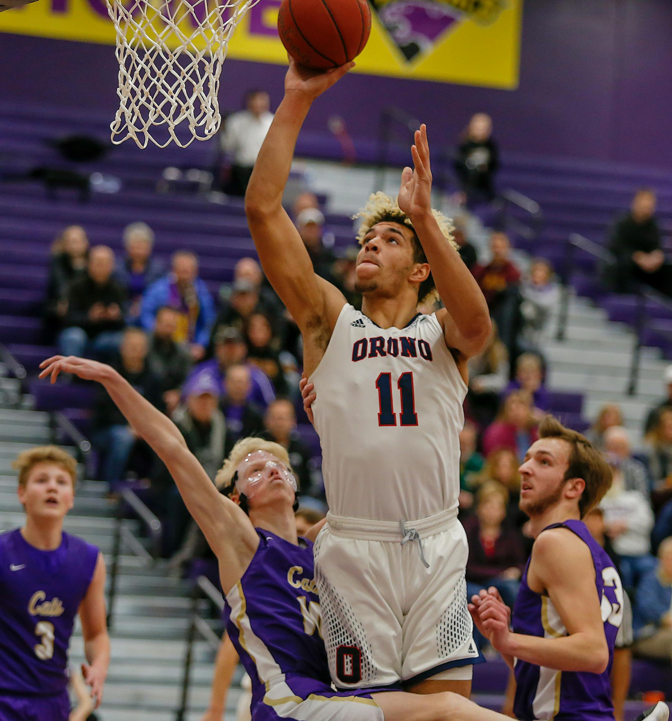 Orono's Jarvis Thomas Omersa (11) drives past Waconia's Ryan Biehn (10) for two of his game-high 27 points. Orono won at Waconia, 85-55. Photo by Mark Hvidsten, SportsEngine