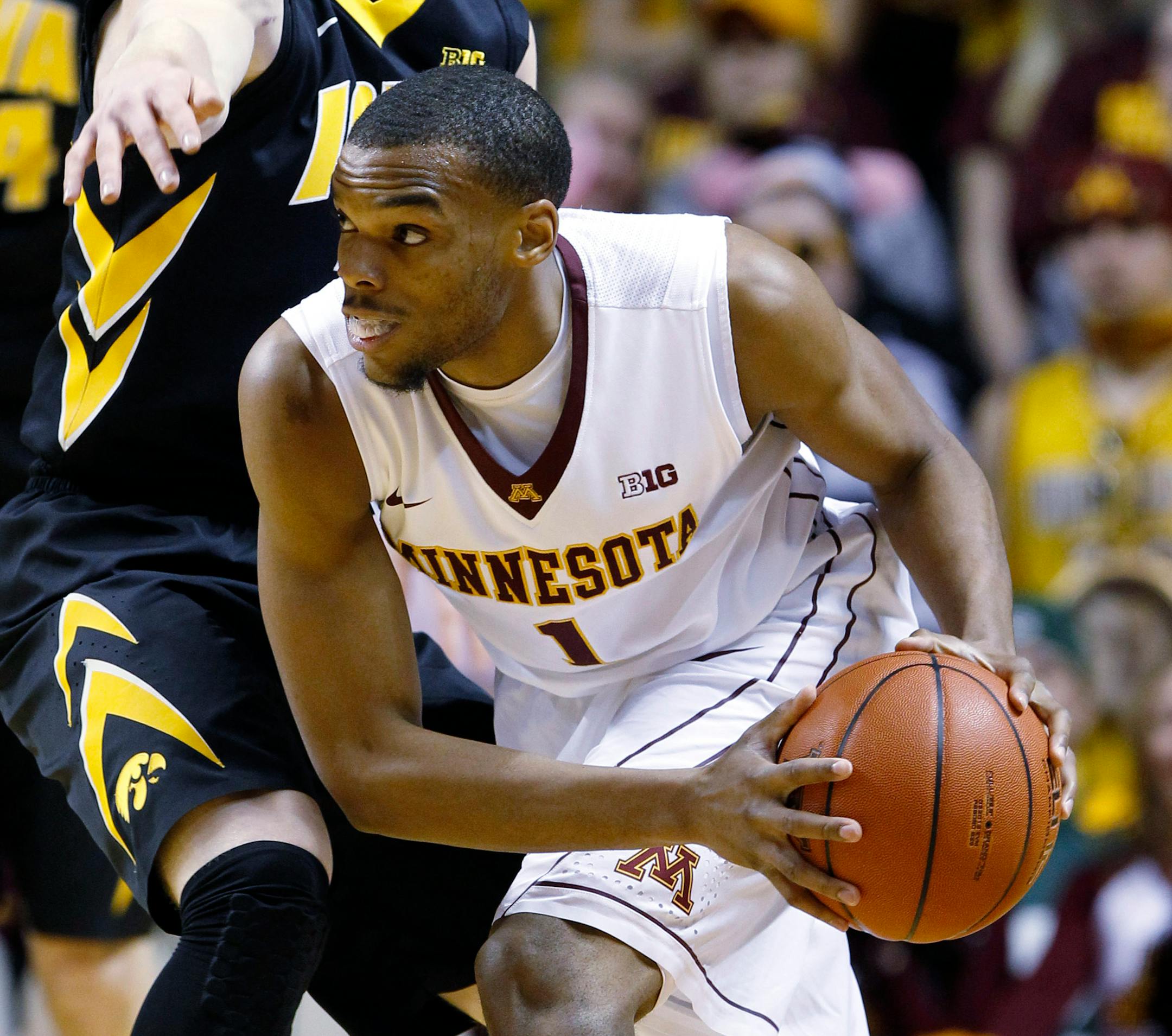 Minnesota guard Andre Hollins (1) looks to pass to a teammate under pressure from Iowa guard Mike Gesell, left, during the first half of an NCAA college basketball game in Minneapolis, Tuesday, Feb. 25, 2014.