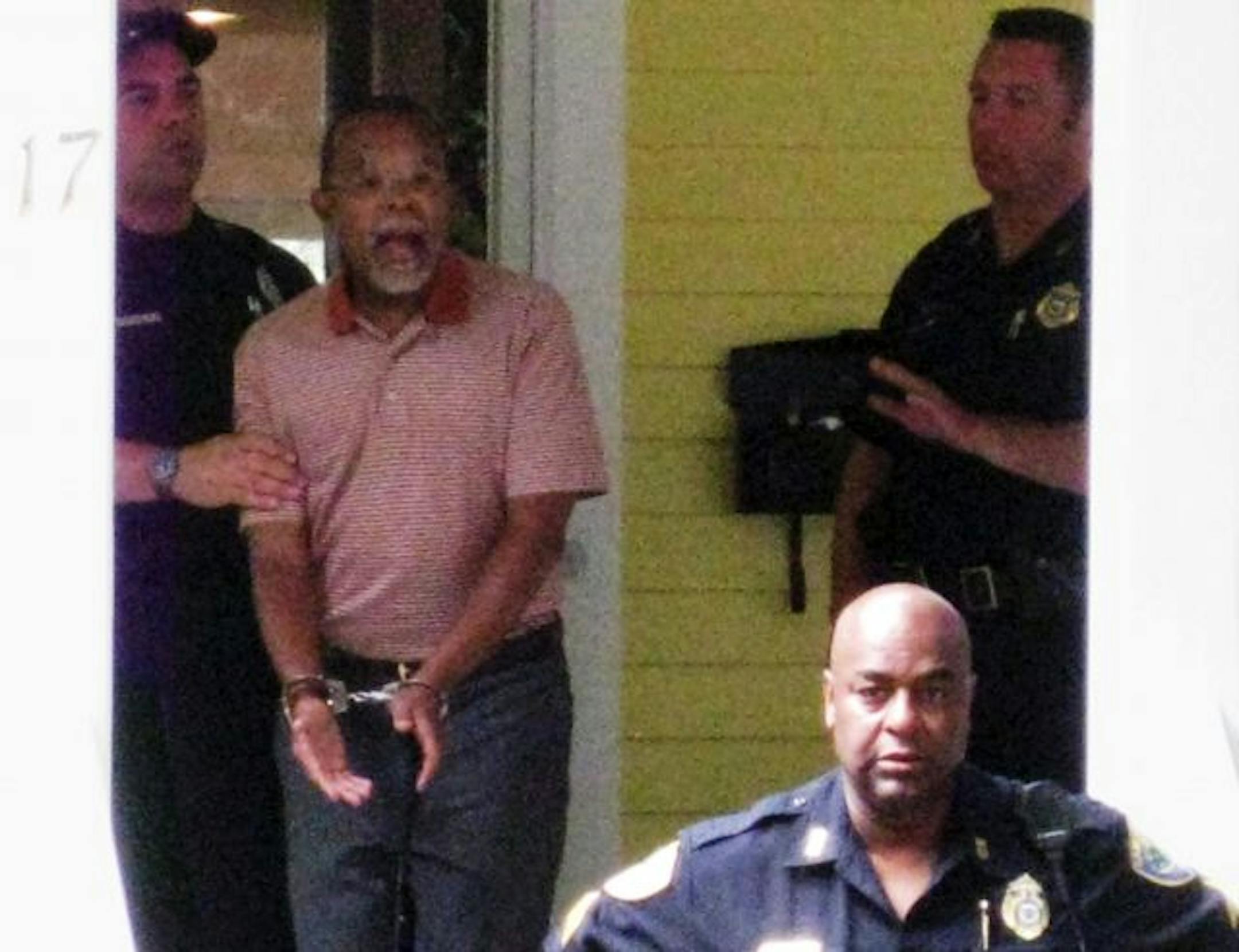 In this photo taken by a neighbor Thursday July 16, 2009 Henry Louis Gates Jr. center, the director of Harvard University's W.E.B. DuBois Institute for African and African American Research, is arrested at his home in Cambridge, Mass. Police say they were called to the home of Gates after a woman reported seeing a man try to pry open the front door. (AP Photo/Demotix Images, B. Carter) MAGS OUT