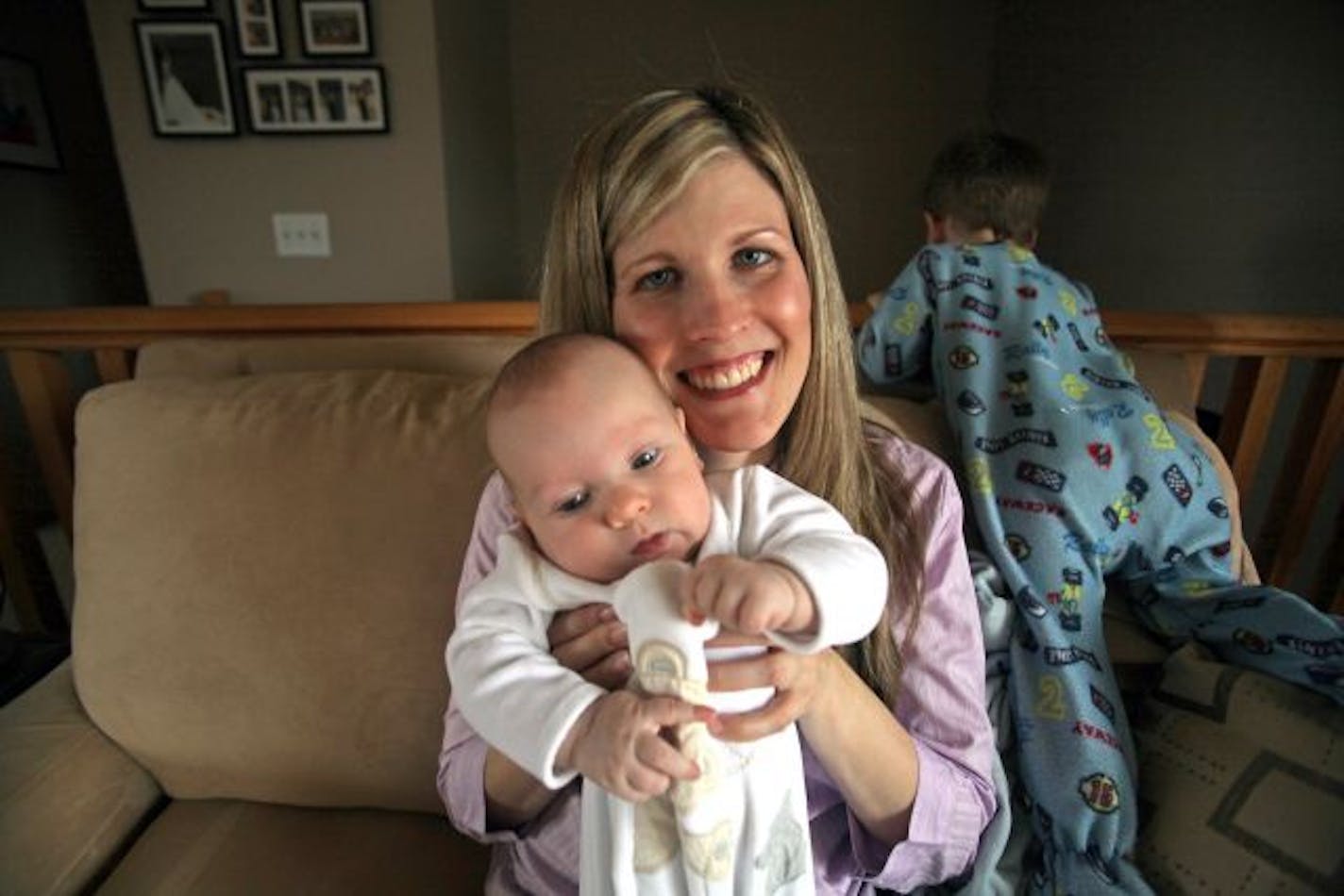 With oldest son, Jordan Maas, crawling around, Ashley Maas held her nine week-old son Payton at their home in Brooklyn Park. Maas had Payton with a midwife and no meds at St. Joseph's Hospital in St. Paul. St. Joeseph's has the lowest c-section rate in the state if not the country.