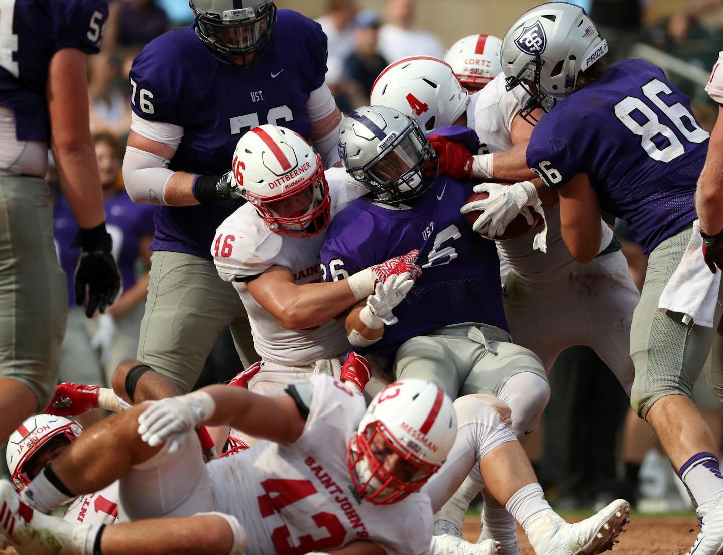 University of St. Thomas running back Josh Parks (26) was pulled down by St. John's University defensive lineman Trevor Dittberner (46) in the second half. ] ANTHONY SOUFFLE &#xef; anthony.souffle@startribune.com Game action from an NCAA football game between the University of St. Thomas and St. John's University Saturday, Sept. 23, 2017 at Target Field in Minneapolis. ORG XMIT: MIN1709231707130197