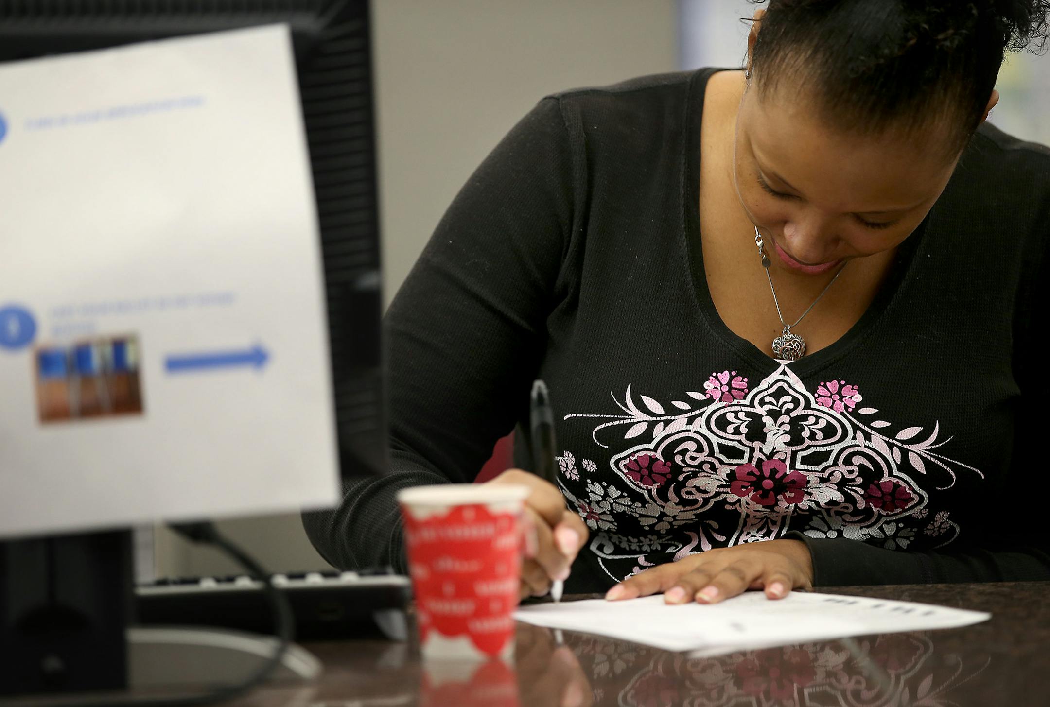 Hennepin County Voting and Elections Office Specialist Chivonne Harston helped a voter with their ballot at the Hennepin County Government Center, Thursday, October 23, 2014 in Minneapolis, MN. ] (ELIZABETH FLORES/STAR TRIBUNE) ELIZABETH FLORES &#x2022; eflores@startribune.com