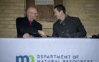 DNR Commissioner Tom Landwehr, and Dominium's Owen Metz shook hands after signing an agreement with Dominium, an affordable housing development and ma