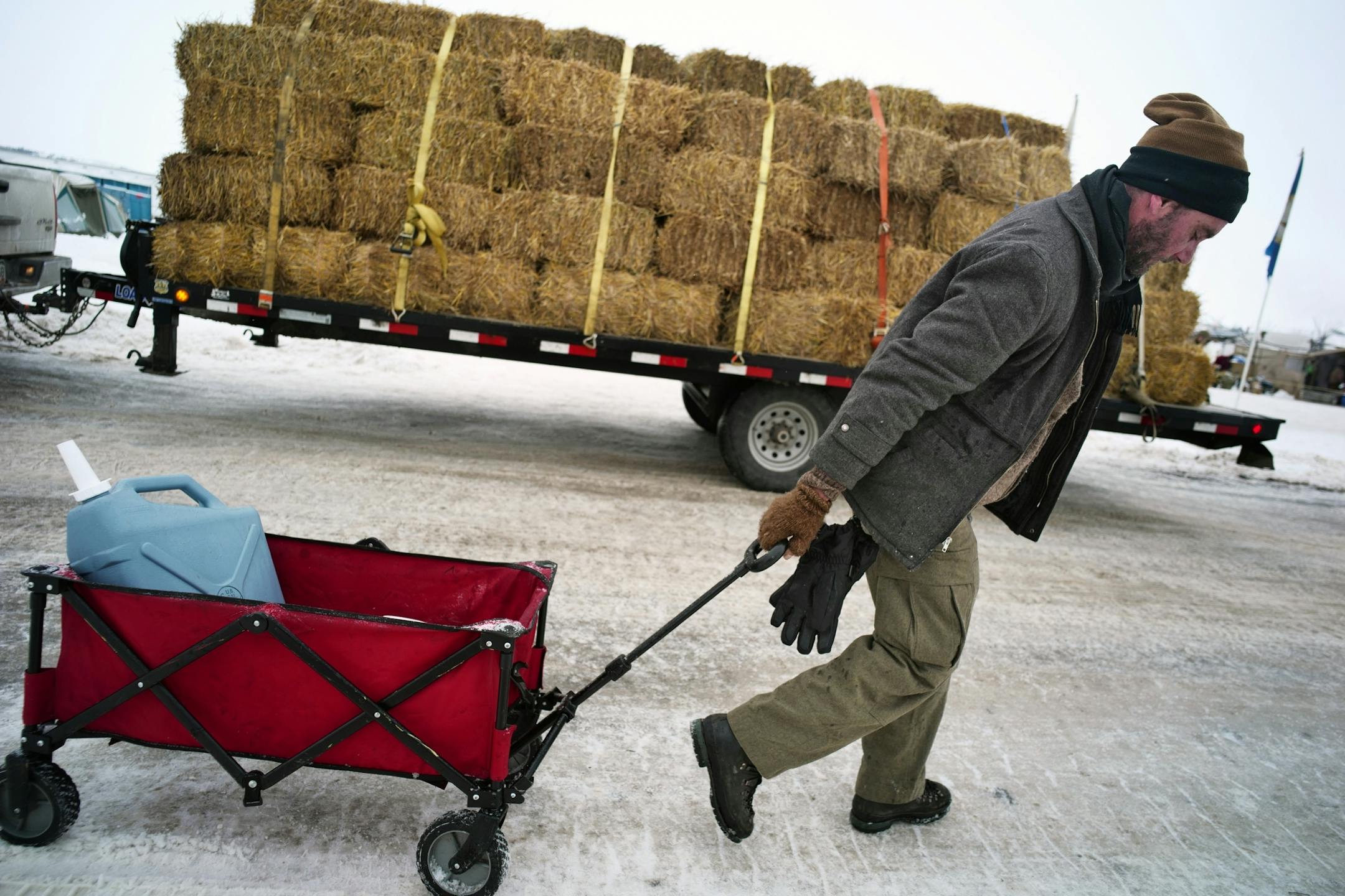 Jonathan Shields, who is from Portland, helped fill containers with water using a bucket because it was partially frozen and would not flow through a spigot on Friday, Dec. 2 at Oceti Sakowin camp. "This is about making billions of dollars for a handful of people," says Shields about why he is opposing the Dakota Access Pipeline.