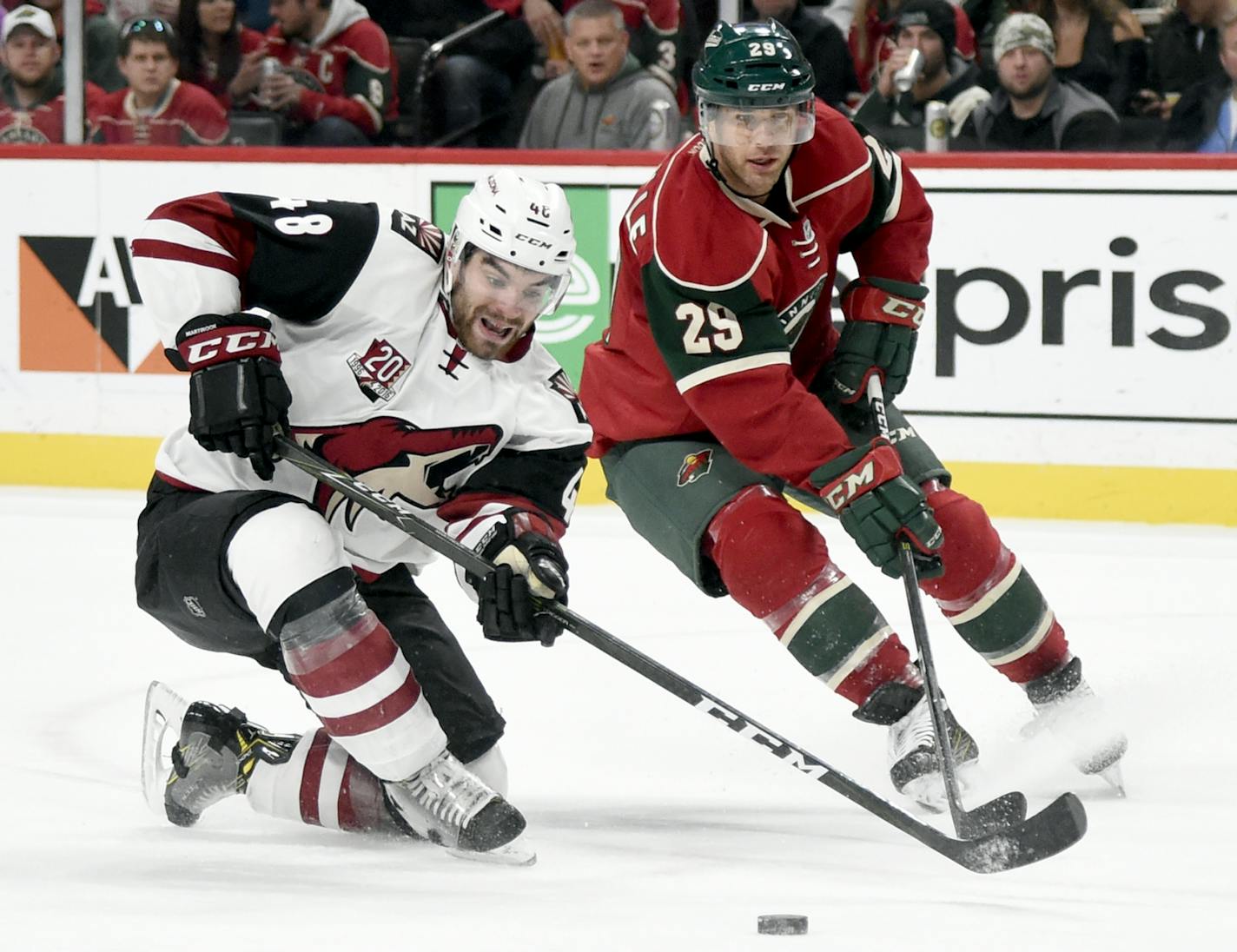 Arizona Coyotes left wing Jordan Martinook (48) and Minnesota Wild right wing Jason Pominville (29) go after the puck during the second period of an NHL hockey game Saturday, Dec. 17, 2016, in St. Paul, Minn.