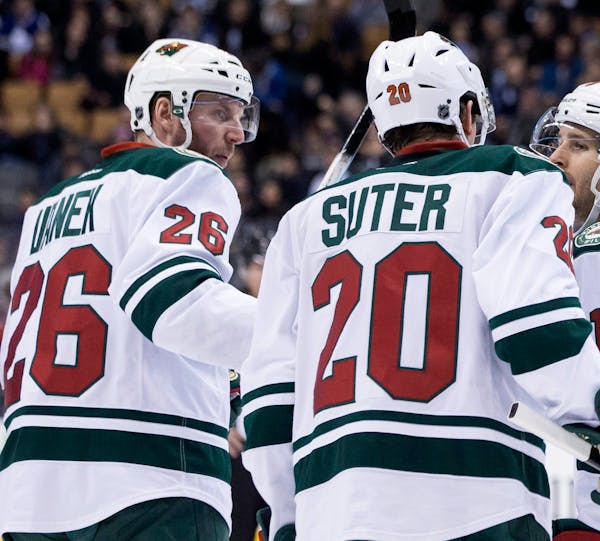 Minnesota Wild's Thomas Vanek, left, celebrates with Ryan Suter (20) and Justin Fontaine after scoring against the Toronto Maple Leafs during third pe
