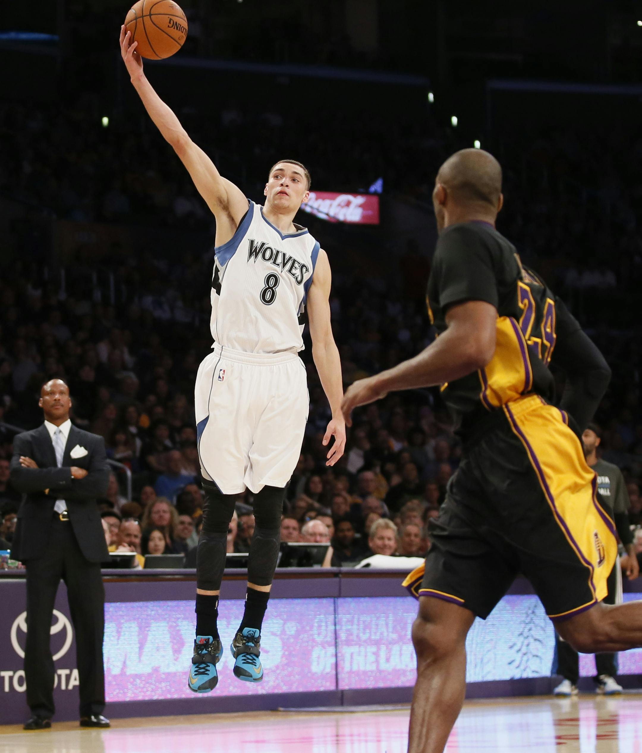 Minnesota Timberwolves' Zach LaVine grabs a loose ball as Los Angeles Lakers' Kobe Bryant looks on during the first half of an NBA basketball game Friday, Nov. 28, 2014, in Los Angeles. (AP Photo/Danny Moloshok)