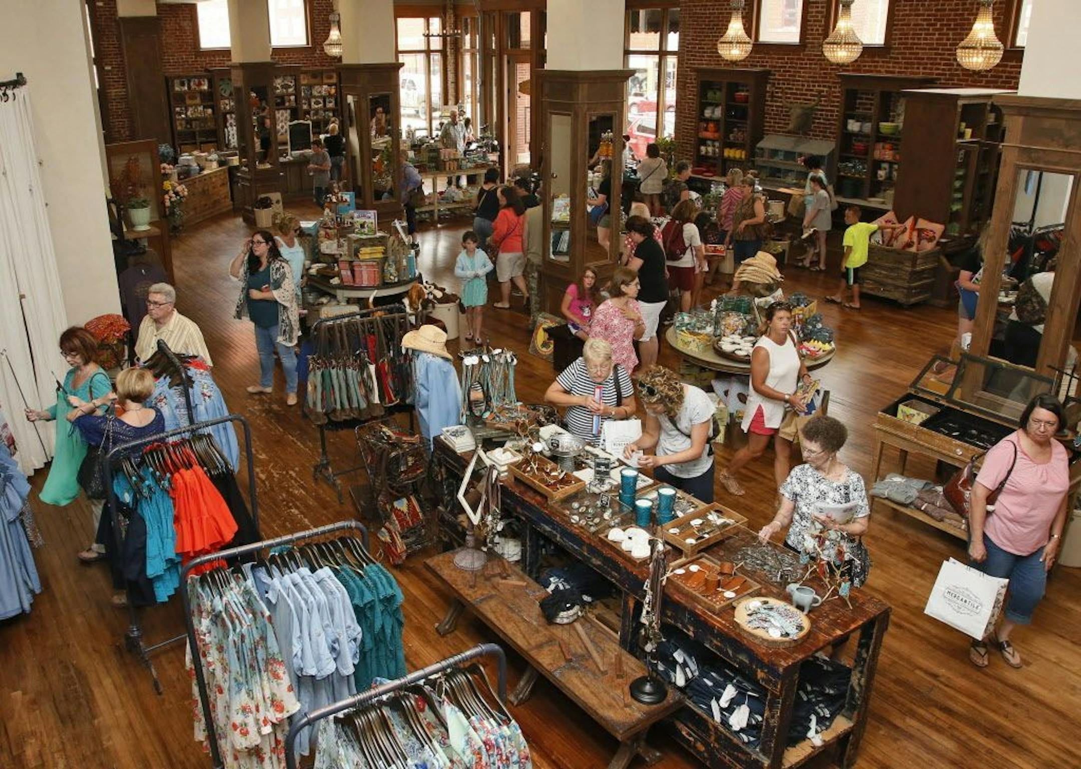 In this Wednesday, June 14, 2017, photo, people shop in The Pioneer Woman Mercantile, a store-bakery-restaurant Ree Drummond and her husband, Ladd, opened in Pawhuska, Okla. Growing up in an Oklahoma town she considered too tiny, Ree Drummond sought the bright lights of a city and headed west for Los Angeles. She never dreamed the journey would send her back to the plains of northeast Oklahoma, to a place with even fewer lights where she's become known and built a brand as "The Pioneer Woman."