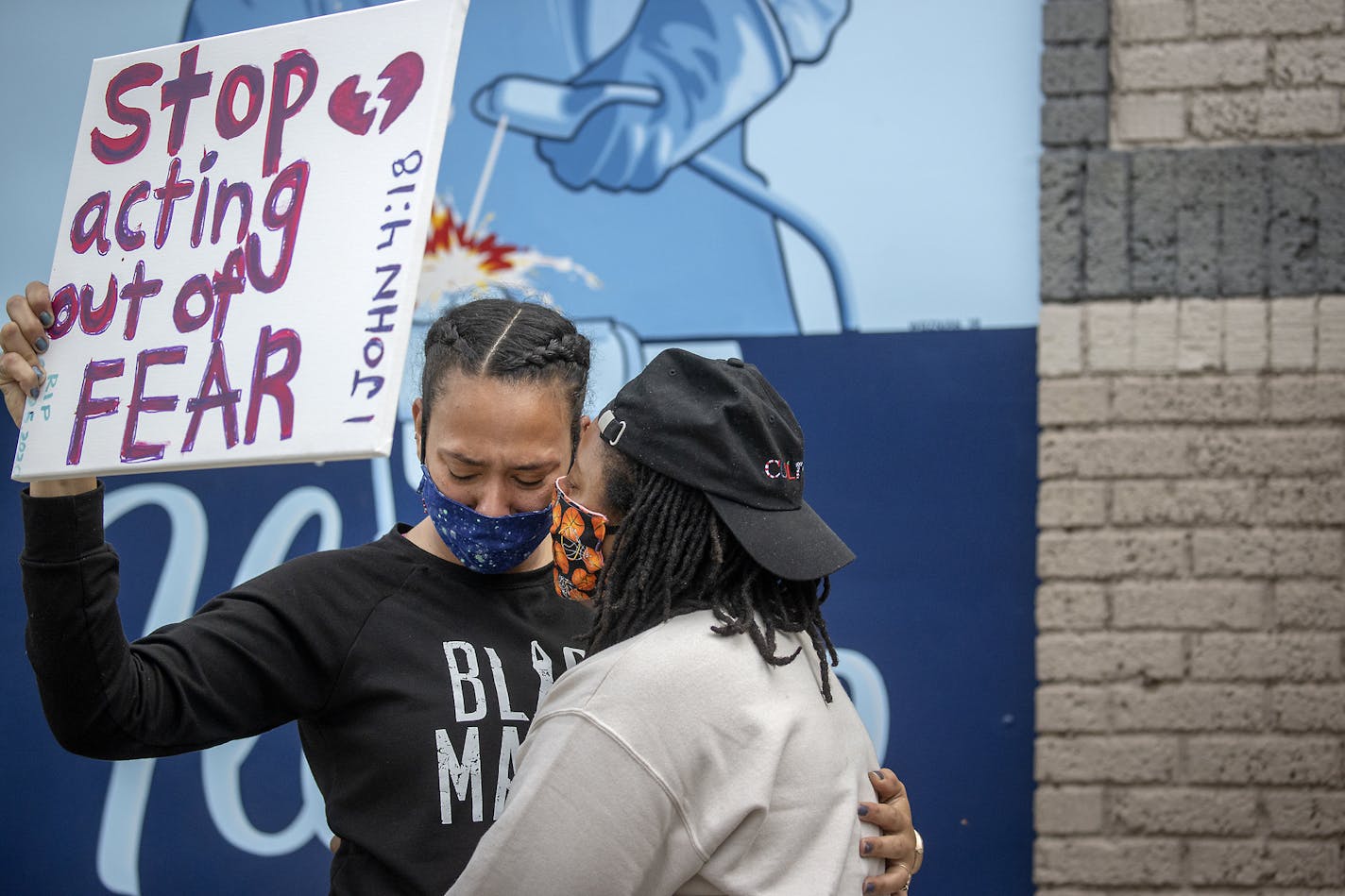 Asha Knight, left, is comforted by Dilonna Johnson, Tuesday, May 26, 2020, in Minneapolis, near the site where a black man, who was taken into police custody the day before, later died. The FBI and Minnesota agents are investigating the death of a black man in Minneapolis police custody after video from a bystander showed a white officer kneeling on his neck during his arrest as he pleaded that he couldn't breathe. (Elizabeth Flores/Star Tribune via AP)