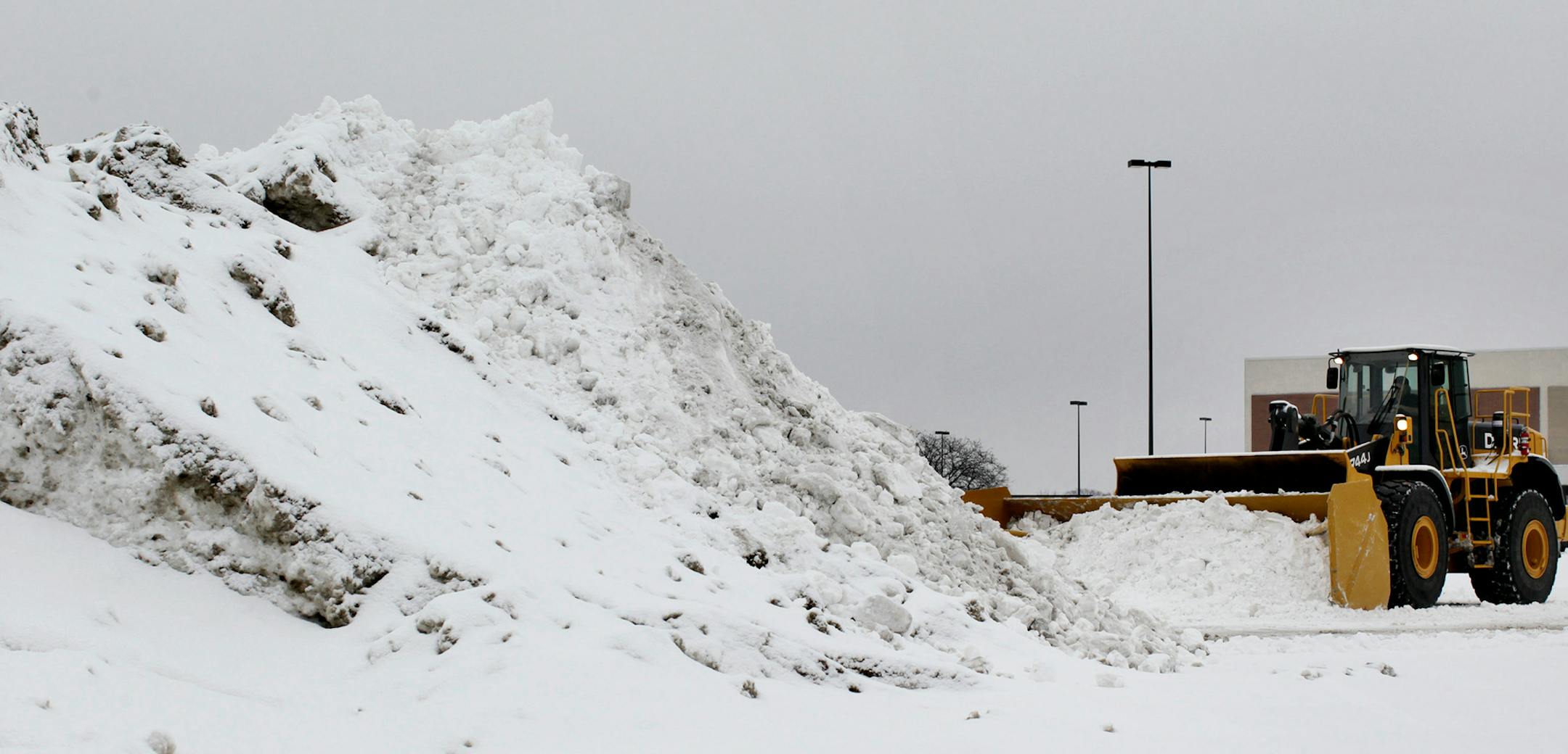 A plow pushes snow into a pile in the Southdale Center parking lot in Edina February 10, 2013. (Courtney Perry/Special to the Star Tribune)