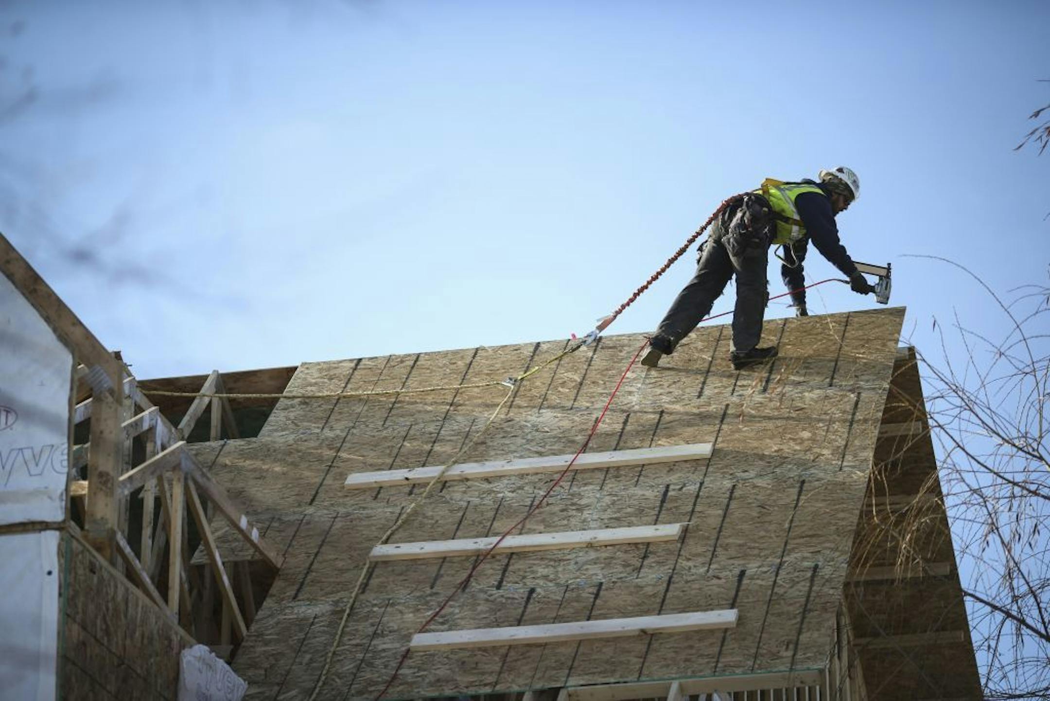 Construction worker Ian Singer worked on the roof of a house construction in Minnetonka, Minn. on Wednesday, December 18, 2014.