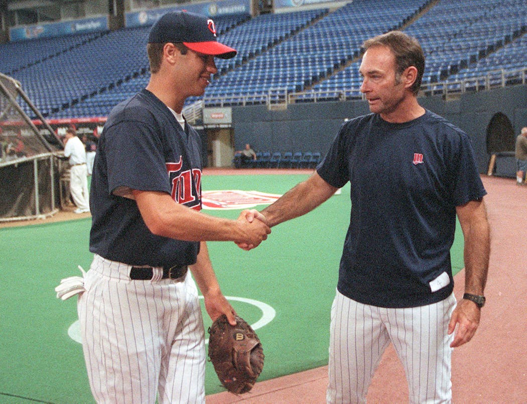 Joe Mauer shakes hands with Paul Molitor after batting practice at the Metrodome