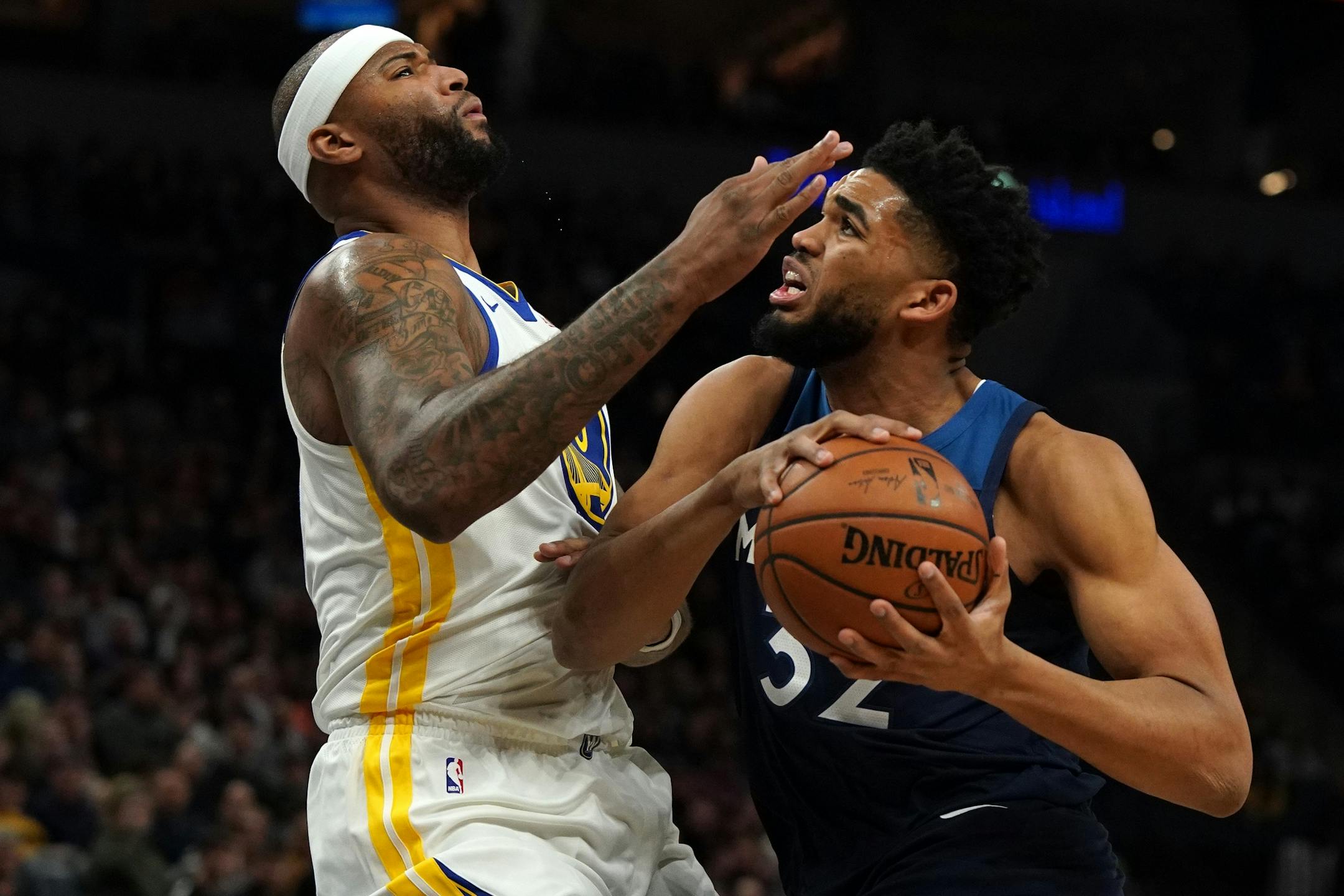 Minnesota Timberwolves center Karl-Anthony Towns (32) collided with Golden State Warriors center DeMarcus Cousins (0) as he drove to the basket in the first half.