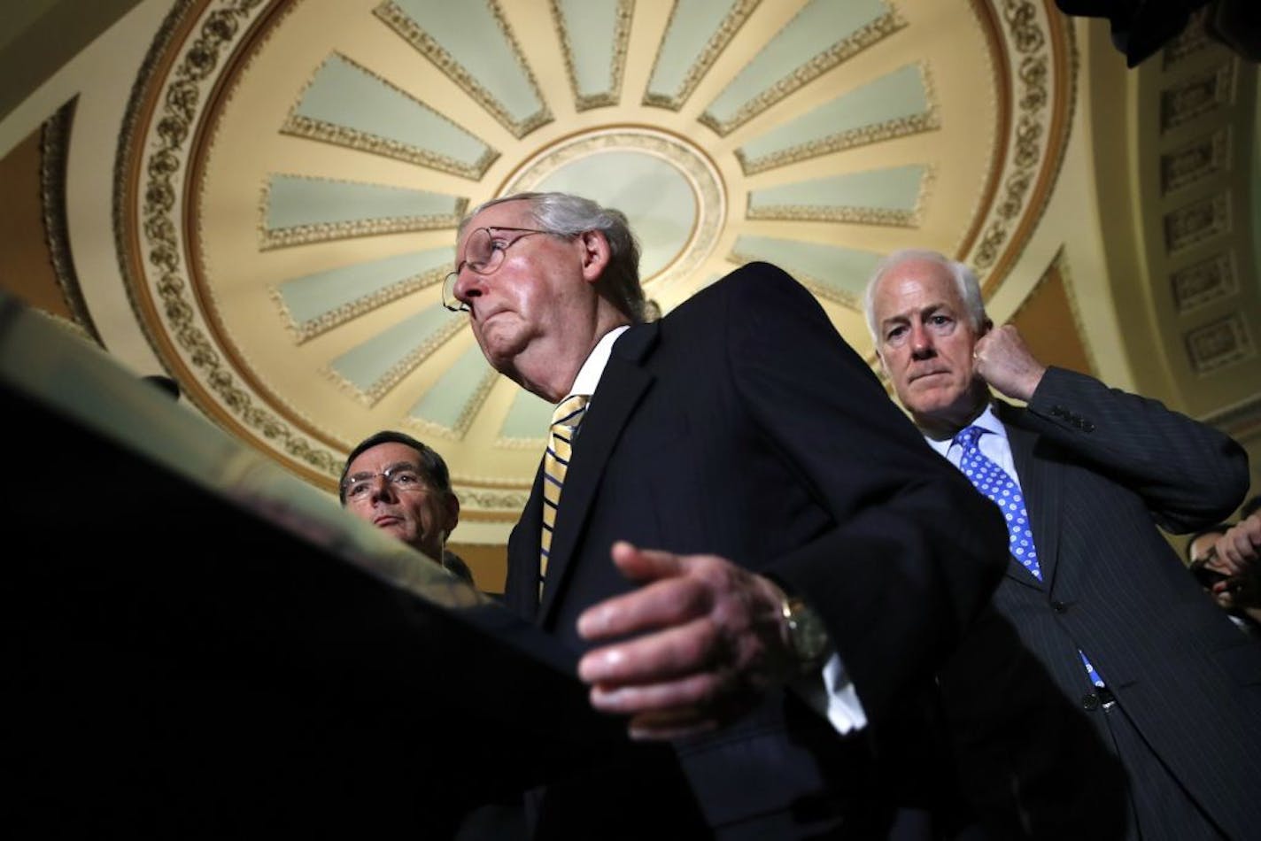 Senate Majority Leader Mitch McConnell of Ky., center, with Senate Majority Whip Sen. John Cornyn, R-Texas, right, and Sen. John Barrasso, R-Wyo., left, talks to reporters on Capitol Hill in Washington, Tuesday, July 25, 2017, after Vice President Mike Pence broke a 50-50 tie to start debating Republican legislation to tear down much of the Obama health care law.