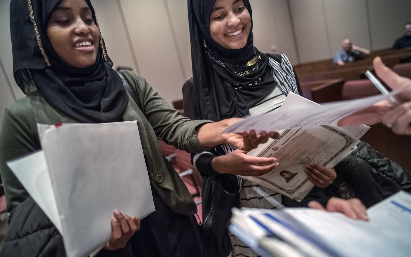 Oromo sisters Huda and Hayat Omer Mohammed, 20, and 22, respectively (L to R) were two of dozens of immigrants became U.S. citizens on Wednesday in St. Paul. Both were signing up to be on the voter registry.] RICHARD TSONG-TAATARII &#x2022; richard.tsong-taatarii@startribune.com