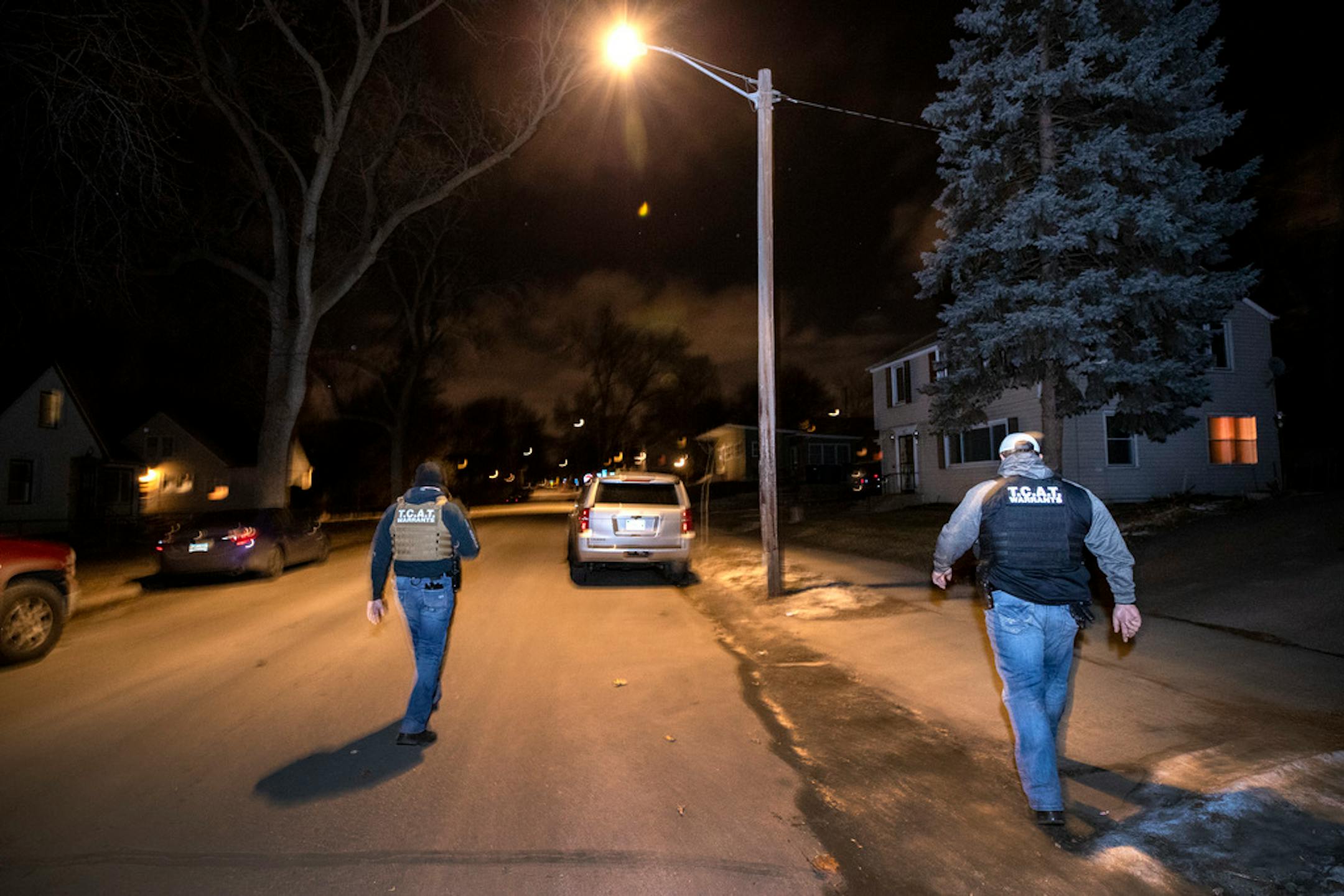 Stew Peters and Richard Leonard walk back to their vehicle after searching for a person skipping bail in Minneapolis. ] CARLOS GONZALEZ • cgonzalez@startribune.com – 2018, Minneapolis, MN, Stew Peters, head of the Twin Cities Apprehension Team, is one of the busiest bounty hunters in the metro