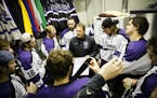 Head Coach Jeff Boeser draws up plays for his team in an equipment room in a period break during the MIAC Championship hockey game against Gustavus Ad