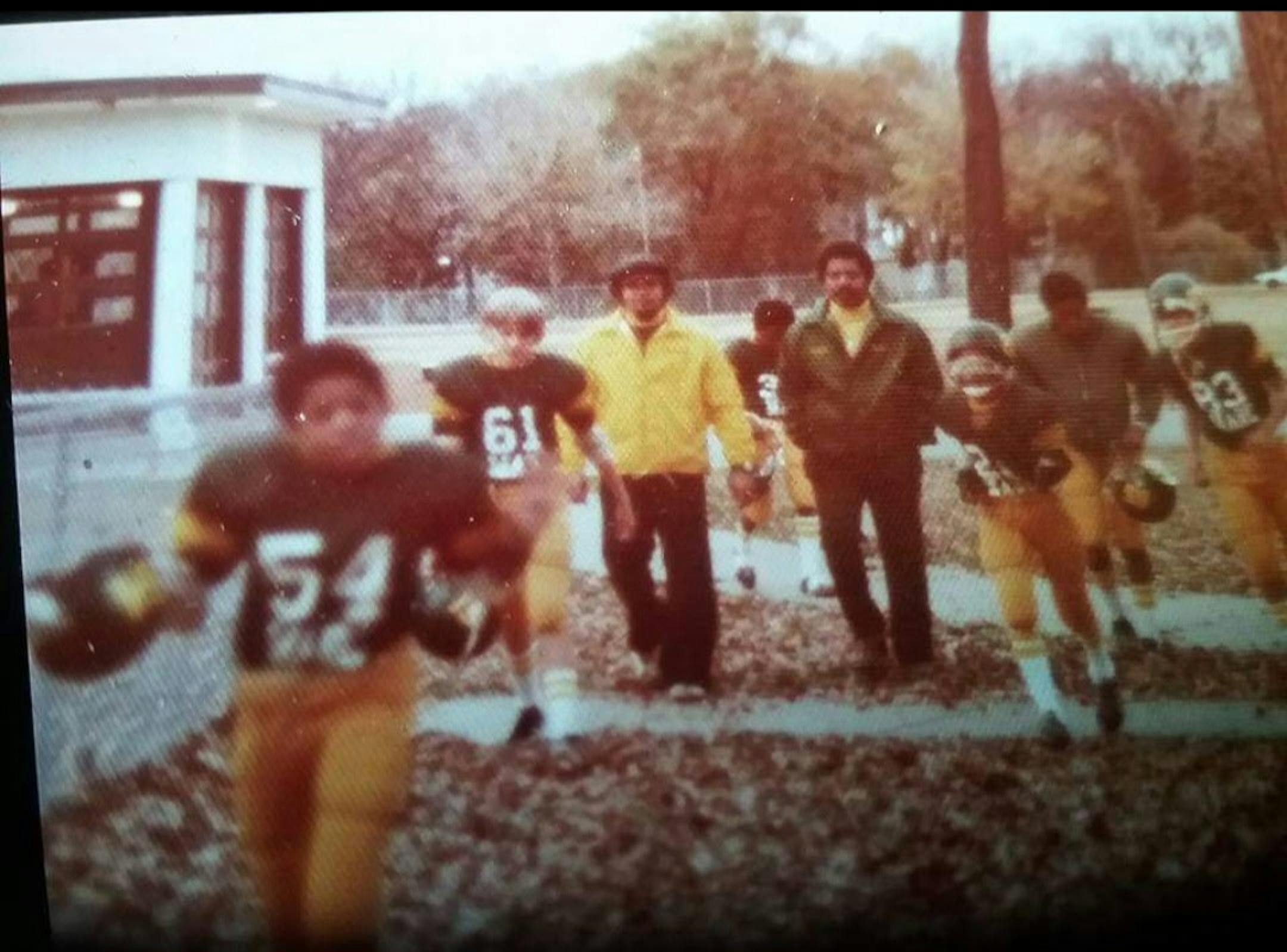 Wallace "Jack" Jackman (left with yellow jacket) walks with members of the McCrae football league he coached in the early 70's. Jackman died on Oct. 27 at the age of 81.