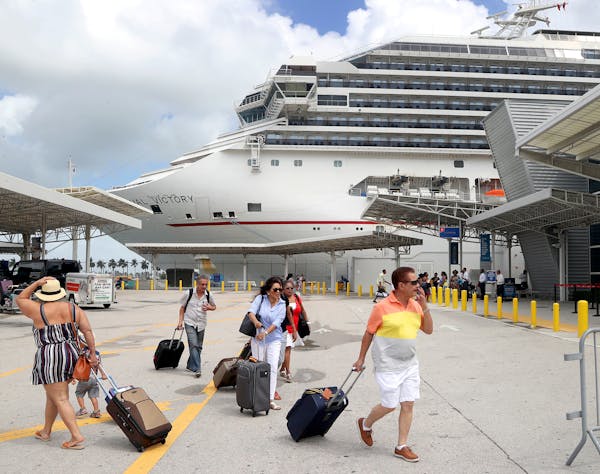Passengers rush to board Carnival's Victory at the Port of Miami as they prepare to sail for Nassau. (Mike Stocker/Sun Sentinel/TNS)