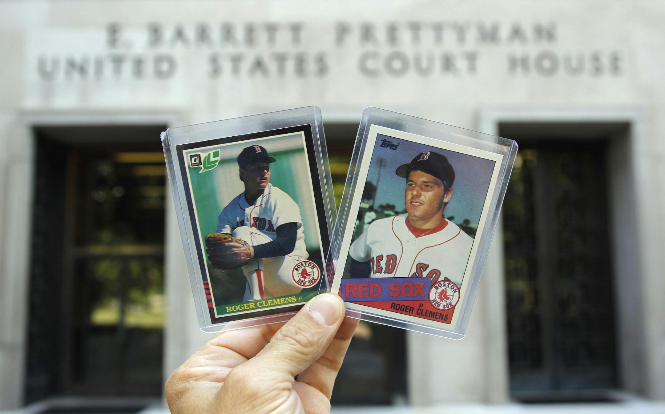 An baseball fan, who did not want to give his name, holds a Leaf rookie baseball card, and a Topps rookie baseball card of former Major League Baseball pitcher Roger Clemens outside federal court in Washington, Tuesday, July 12, 2011, as jury selection continued in Clemens perjury trial. The fan was hoping to get Clemens to autograph the cards.