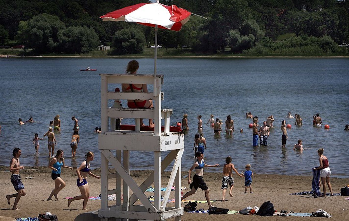 JIM GEHRZ � jgehrz@startribune.com Minneapolis/June 23, 2009/1:30PM As temperatures rose into the 90�s, the number of people seeking to cool off and have fun increased at Lake Nokomis� Main Beach in Minneapolis. At center a lifeguard monitored the swimming area.