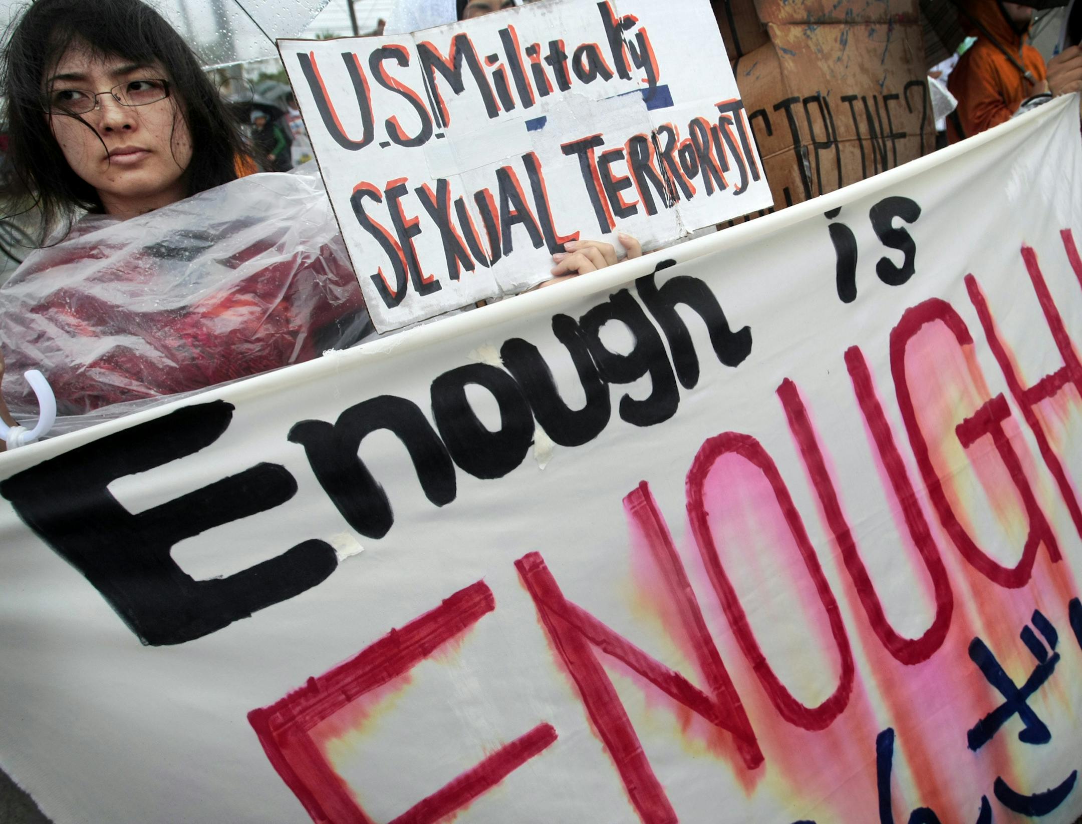 FILE - In this March 23, 2008 file photo, a protester holds a placard during a rally against an alleged rape in February of a 14-year-old girl by an American serviceman in Okinawa islands, southwestern Japan. An Associated Press investigation into the militaryís handling of sexual assaults in Japan has found a pattern of random and inconsistent judgments in which most offenders are not incarcerated. Instead, commanders have ordered ìnonjudicial punishmentsî that ranged from docked