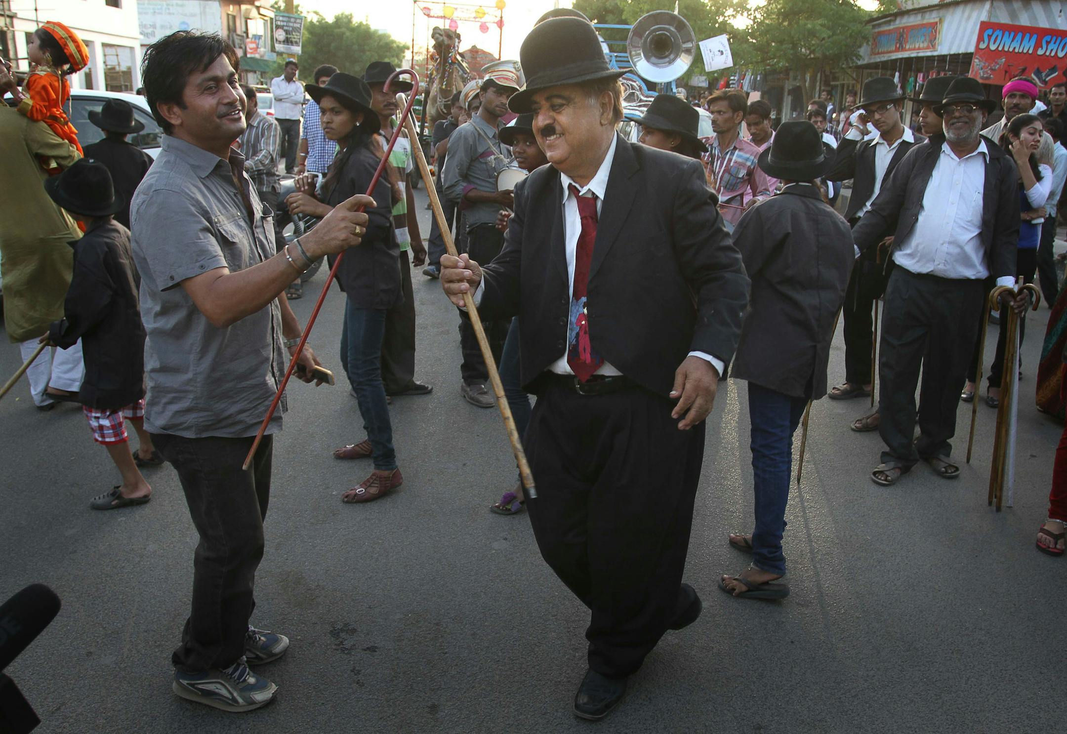 Members and supporters of the Charlie Circle, a Charlie Chaplin fan-club, dance during the annual parade to celebrate the birthday of Charlie Chaplin in Adipur, Gujarat state, India, Tuesday, April 16, 2013. Canes in hand and bowler hats firmly in place, dozens of Charlie Chaplin impersonators tramped through the streets of this small port town in western India on Tuesday to celebrate the birthday of the legendary comic actor and filmmaker. (AP Photo/Ajit Solanki)