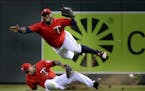 Minnesota Twins right fielder Miguel Sano, top, and second baseman Eduardo Nunez collide in right field while chasing a fly ball hit by the Los Angele