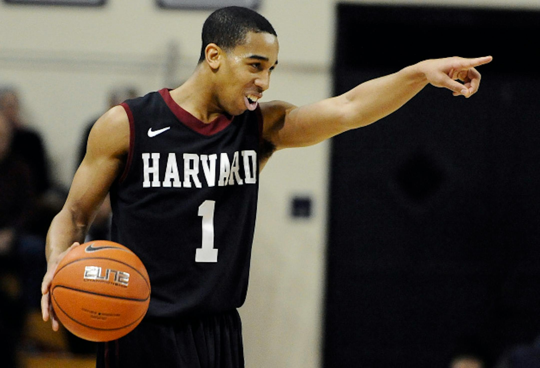 Harvard's Siyani Chambers, points and smiles at his team as he dribbles in the final seconds of an NCAA college basketball game against Yale, Friday, March 7, 2014, in New Haven, Conn. Harvard won 70-58. (AP Photo/Jessica Hill) ORG XMIT: CTJH110