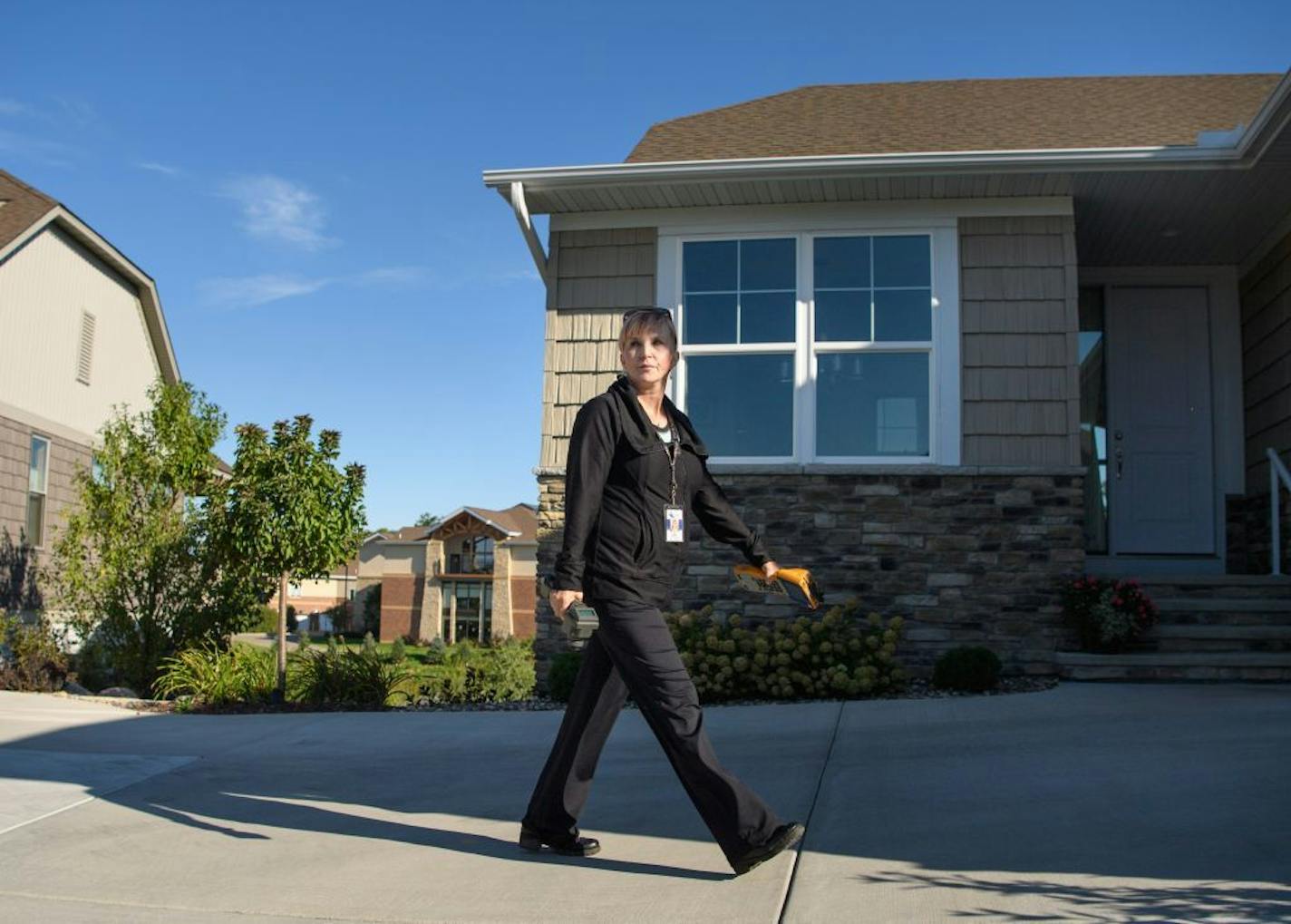 Jenny Rhoades, a public works meter reader for Bloomington walked briskly from house to house in a new Bloomington neighborhood capturing water readings from a sensor on the side of each house.