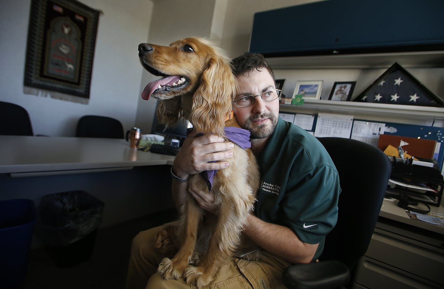 Tony Tengwall gave his dog Fitz a hug in his office, Wednesday, April 29, 2015 in Anoka, MN. After Tengwall returned home from his deployment in Baghdad with the National Guard, he suffered with PTSD for about 6 years. He then was given Fitz , a therapy dog trained to help veterans with PTSD, and helped him. He brings Fitz with him to work everyday to help him with anxiety. ] (ELIZABETH FLORES/STAR TRIBUNE) ELIZABETH FLORES &#x2022; eflores@startribune.com