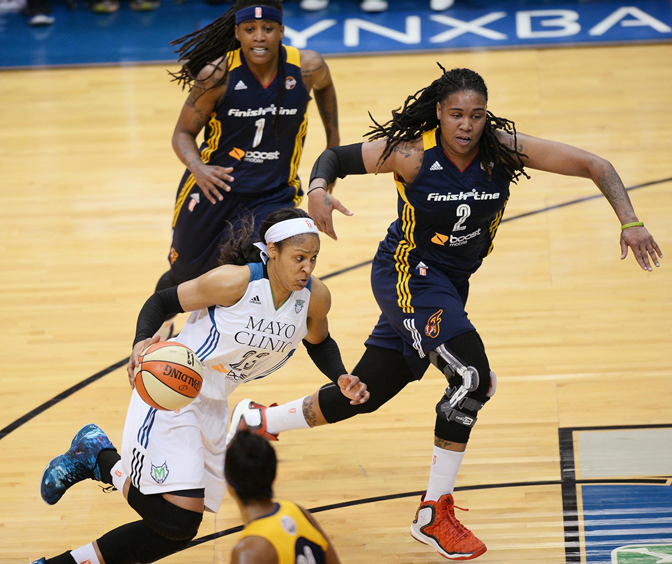 Minnesota Lynx forward Maya Moore (23) drives with Indiana Fever guard Shavonte Zellous (1) and Indiana Fever forward Erlana Larkins (2) in pursuit during the first half.