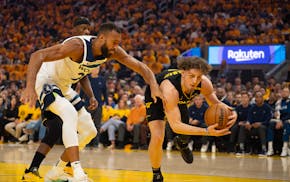 Warriors guard Brandin Podziemski (2) saves the ball from going out of bounds ahead of Timberwolves center Rudy Gobert (27) on Monday in San Francisco