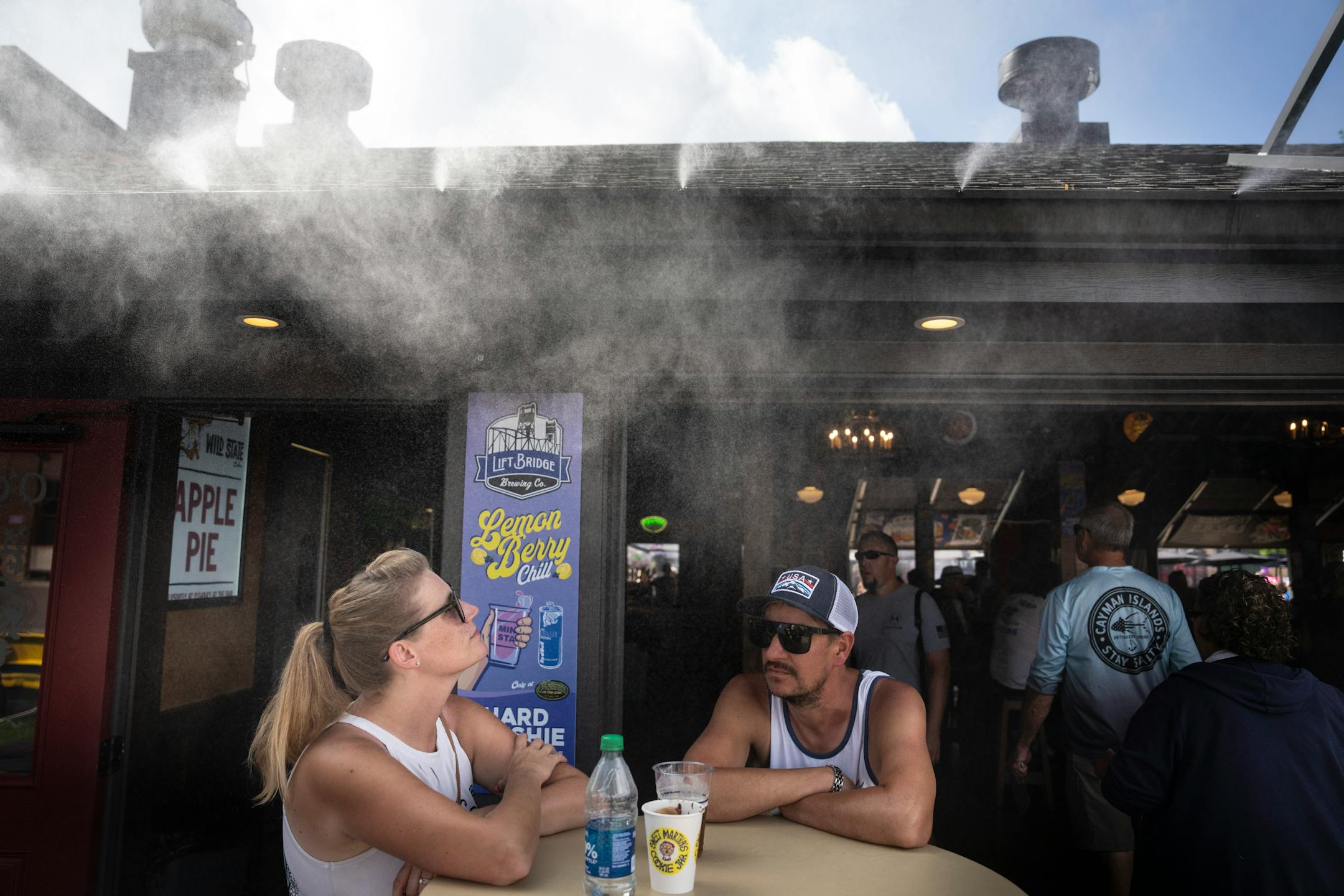 "It's beautiful under this thing," said Chad Vlien of the mist spraying over the table while having a drink with his wife Jen Vlien at O'Gara's on the first day of the Minnesota State Fair on Thursday, Aug. 24, 2023 in Falcon Heights, Minn.