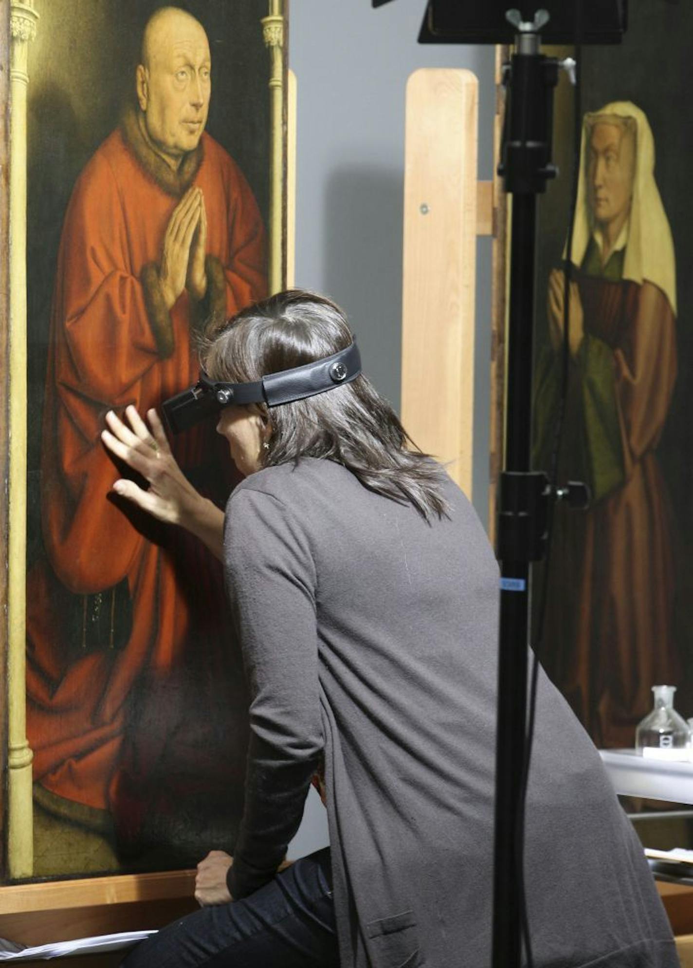 FILE - In this Oct. 11, 2012 file photo, a restorer inspects one of the 24 framed panels of the Altarpiece or Adoration of the Mystic Lamb, at the Fine Arts museum in Ghent, Belgium. If Rotterdam's stunning heist of Picasso, Monet and Matisse paintings last month focused attention on the murky world of art theft, Ghent's gothic Saint Bavo cathedral has been at the center of a crime that has bedeviled the art world for decades. The Just Judges panel of the Van Eyck brothers� multi-panel Gothic ma