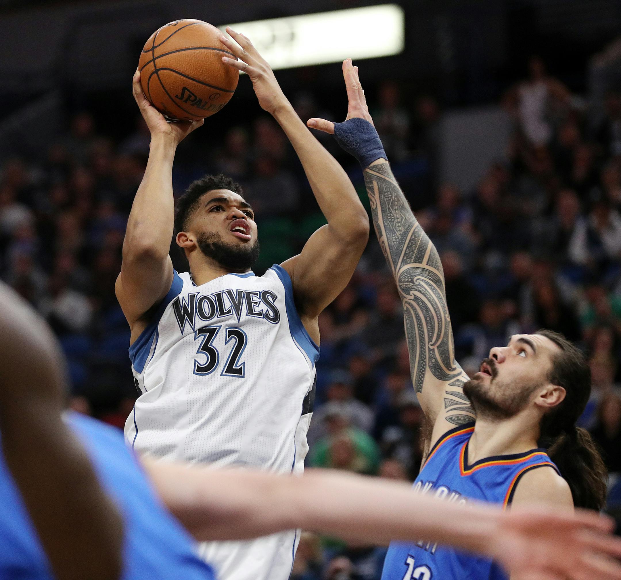 Minnesota Timberwolves center Karl-Anthony Towns (32) takes a shot over the head of Oklahoma City Thunder center Steven Adams (12) during the first half.