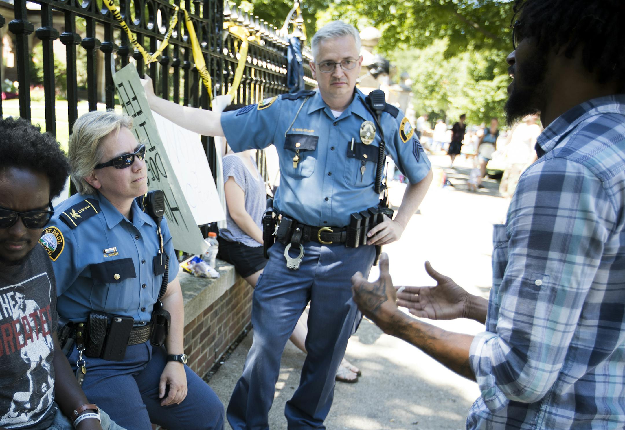 Deputy Chief Mary Nash talked with people outside the governor's residence including Jacob Ladda, at right, about how they could not set up sleeping tents per a St. Paul city ordinance during a peaceful protest on Saturday, July 9, 2016 in St. Paul, Minn. ] RENEE JONES SCHNEIDER ï reneejones@startribune.com