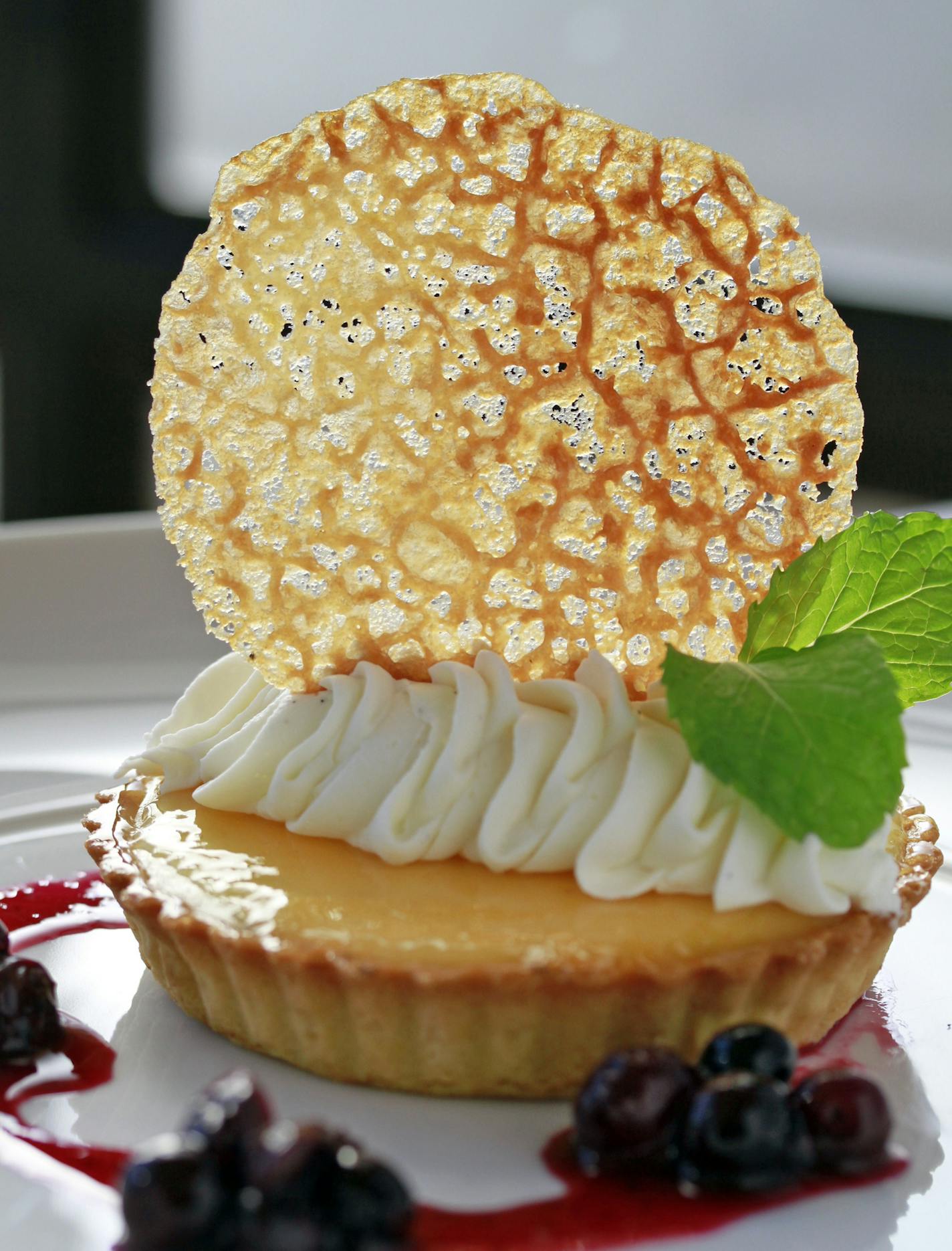 Lemon tart with a crispy tuile cookie and blueberries.