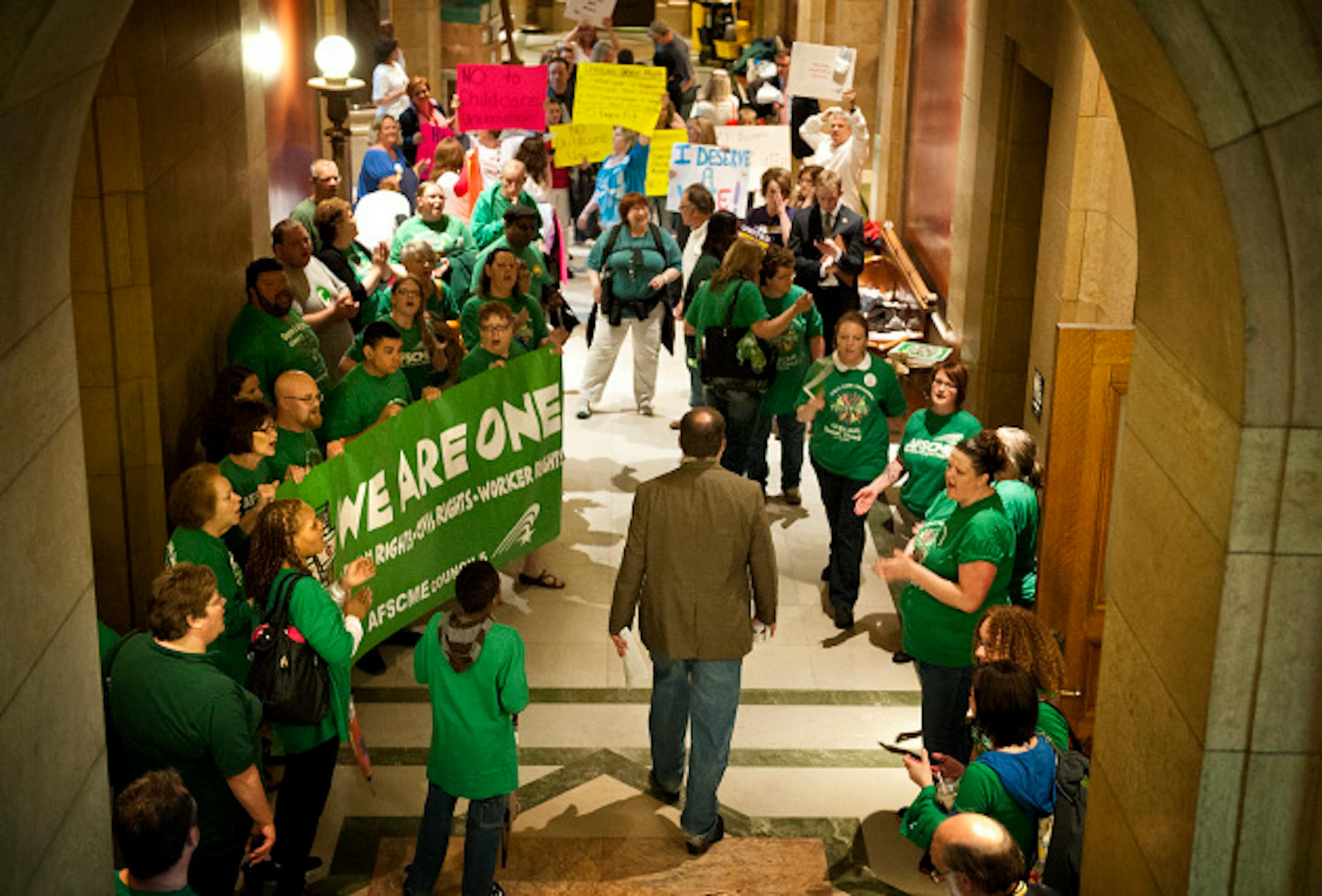 Assistant Minority Leader Kelby Woodard, R-Belle Plaine walked through the gauntlet of cheering advocates for both sides of the daycare unionization demonstrators.  Vote Yes and Vote No echoed in throughout the Capitol Saturday, May 18, 2013  as legislators were set to debate the childcare unionization bill.     ]   GLEN STUBBE * gstubbe@startribune.com