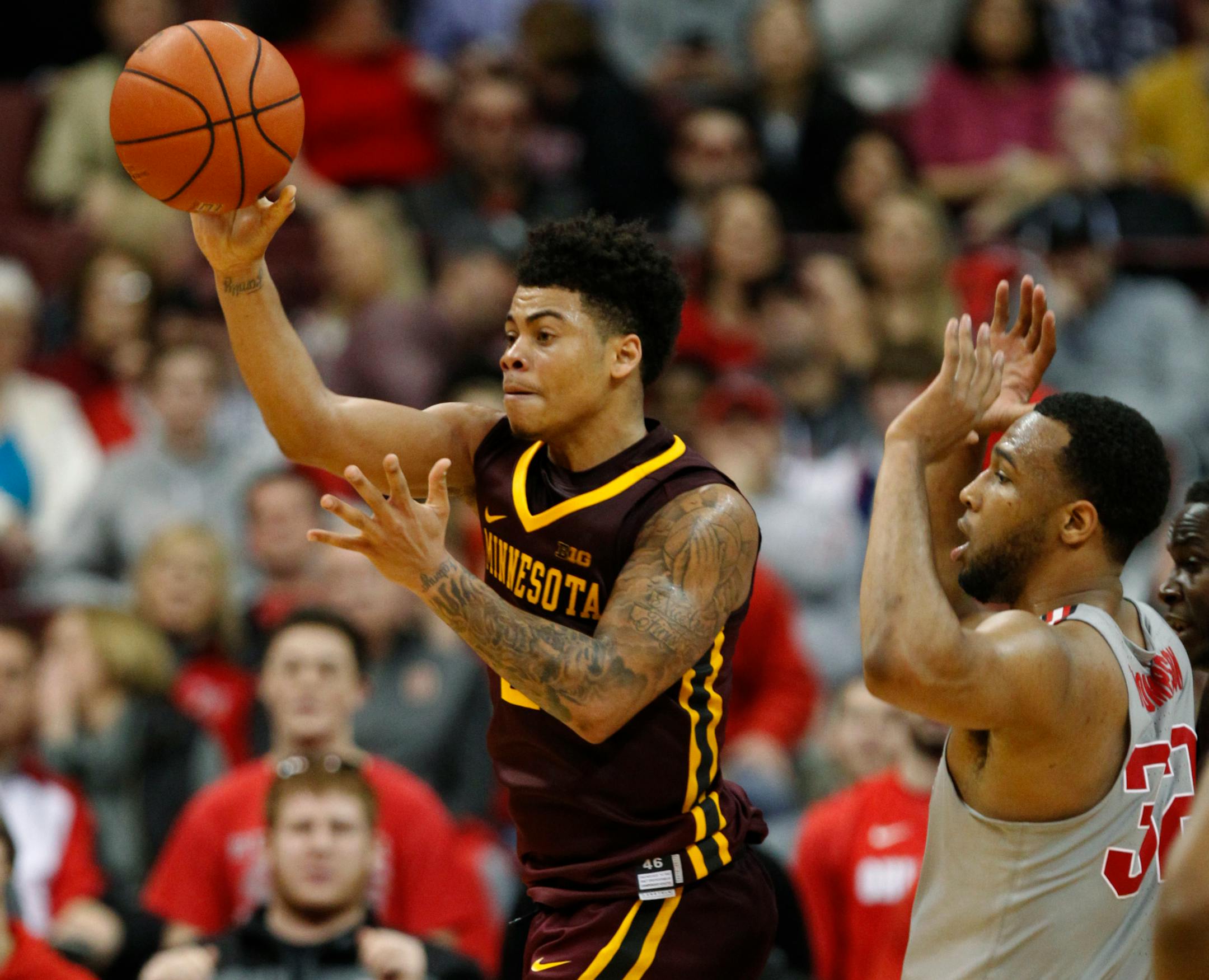 Minnesota guard Nate Mason, left, passes the ball against Ohio State center Trevor Thompson during the second half on Wednesday