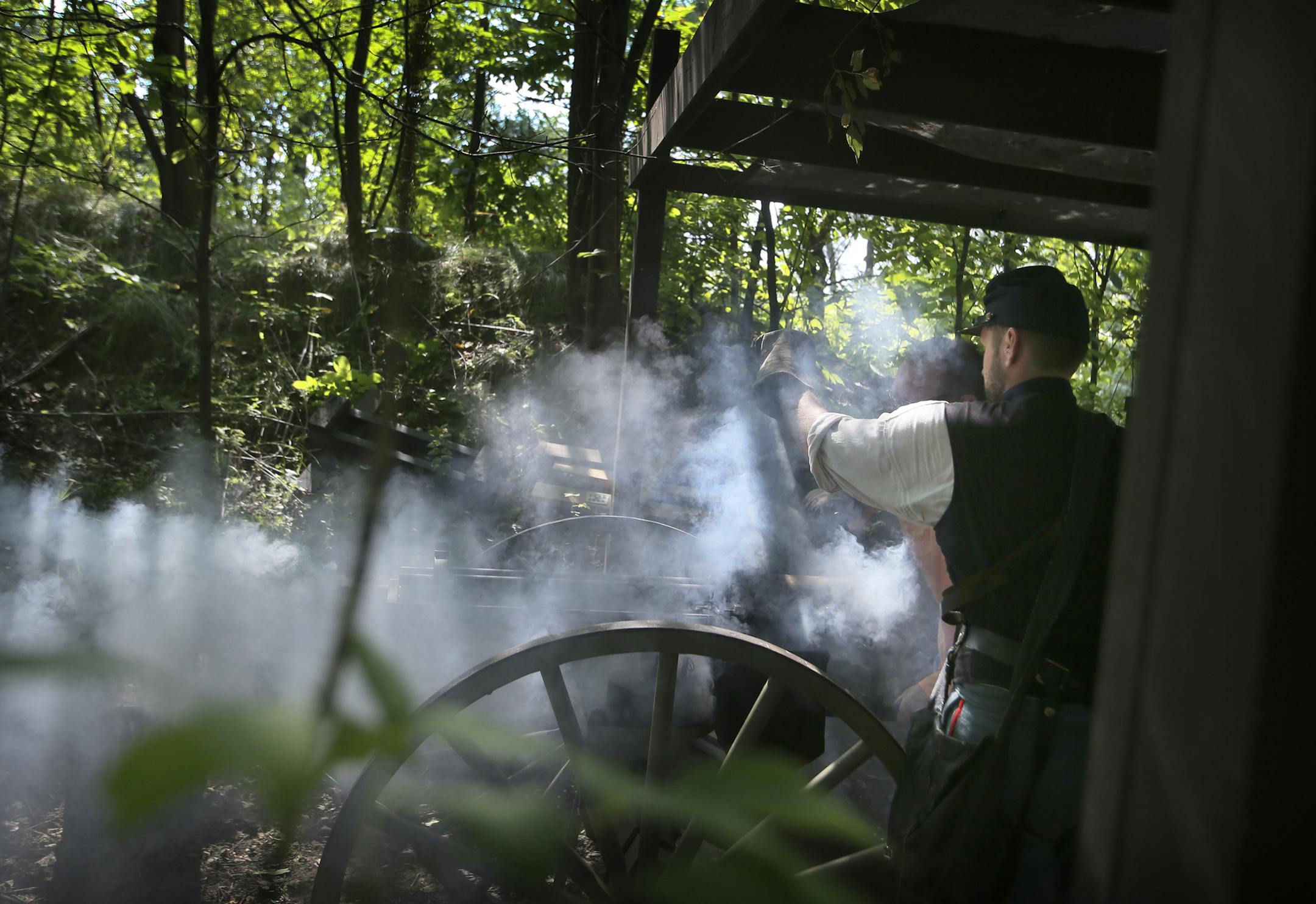 Smoke fills the air as Civil War re-enactor Jason Grimm of the Battery 1 First US Artillery, assits Mike Walker of Albert Lea in firing a Gatling gun during the "Shooter's Round Up," at Ahlman's Gun Shop Saturday, Aug. 24, 2013, in Morristown, MN.](DAVID JOLES/STARTRIBUNE) djoles@startribune.com Ahlman's Gun Shop of Morristown in southern Minnesota has their big gun blowout know as "Shooter's Round Up" this weekend. Cannons, tanks, machine guns, sporting arms: all of it is shot by the thousands
