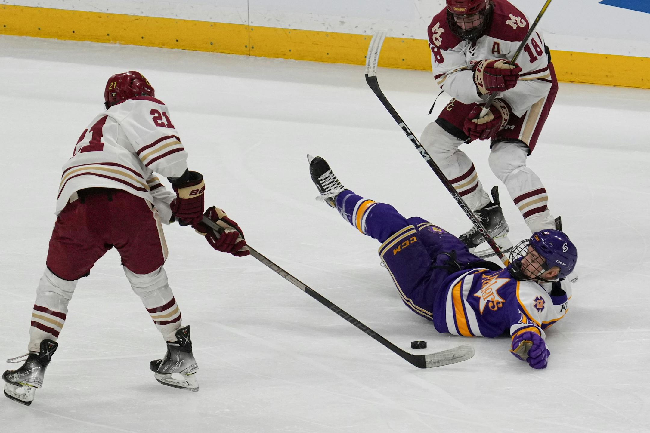 Cretin-Derham Hall forward Charles Owens (11) hits the ice between Maple Grove forward Lucas Busch (21) and Maple Grove forward Blake Steenerson (18) in the first period.