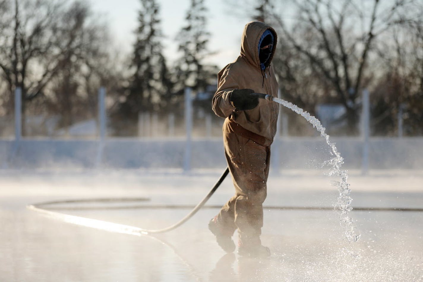 Tiara Medlock, a park keeper with the Minneapolis Parks and Recreation maintenance department, sprayed water to form an ice skating rink at Windom Park as temperatures dipped below 0 Thursday.