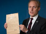 Minnesota Secretary of State Steve Simon holds up an original voting instruction card printed in Norwegian during a news conference in St. Paul on Thu