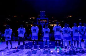 Maccabi Ra’anana players stood together during a moment of silence Tuesday night at Target Center wearing T-shirts with the faces of some hostages t