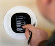 Center for Energy & Environment HVAC consultant Taylor Smith sets a programable thermostat Oct. 13, 2022 in Minneapolis. DAVID JOLES • david.joles@s